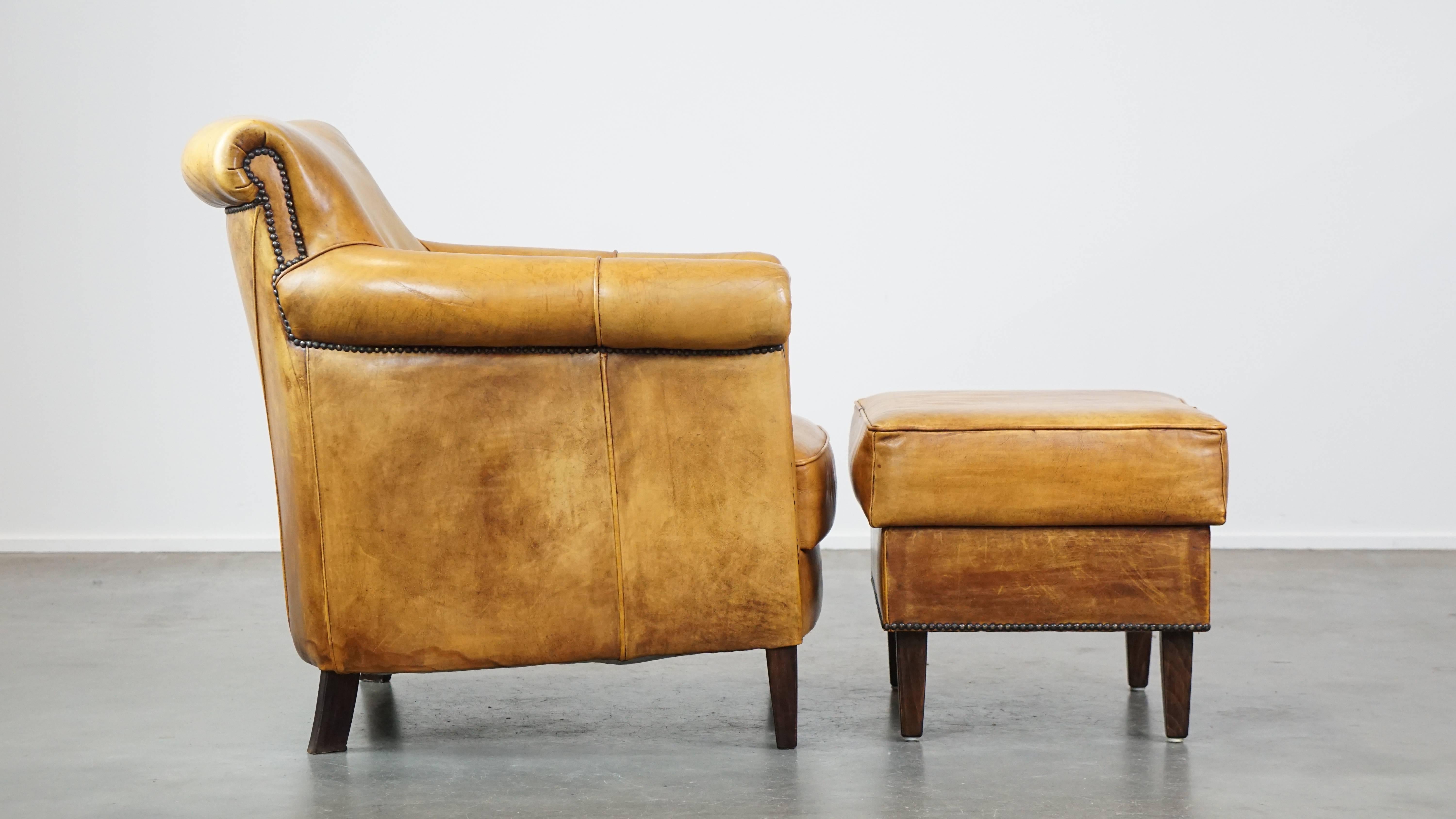 Hand-Crafted Comfortable leather armchair with ottoman, finished with decorative nails For Sale