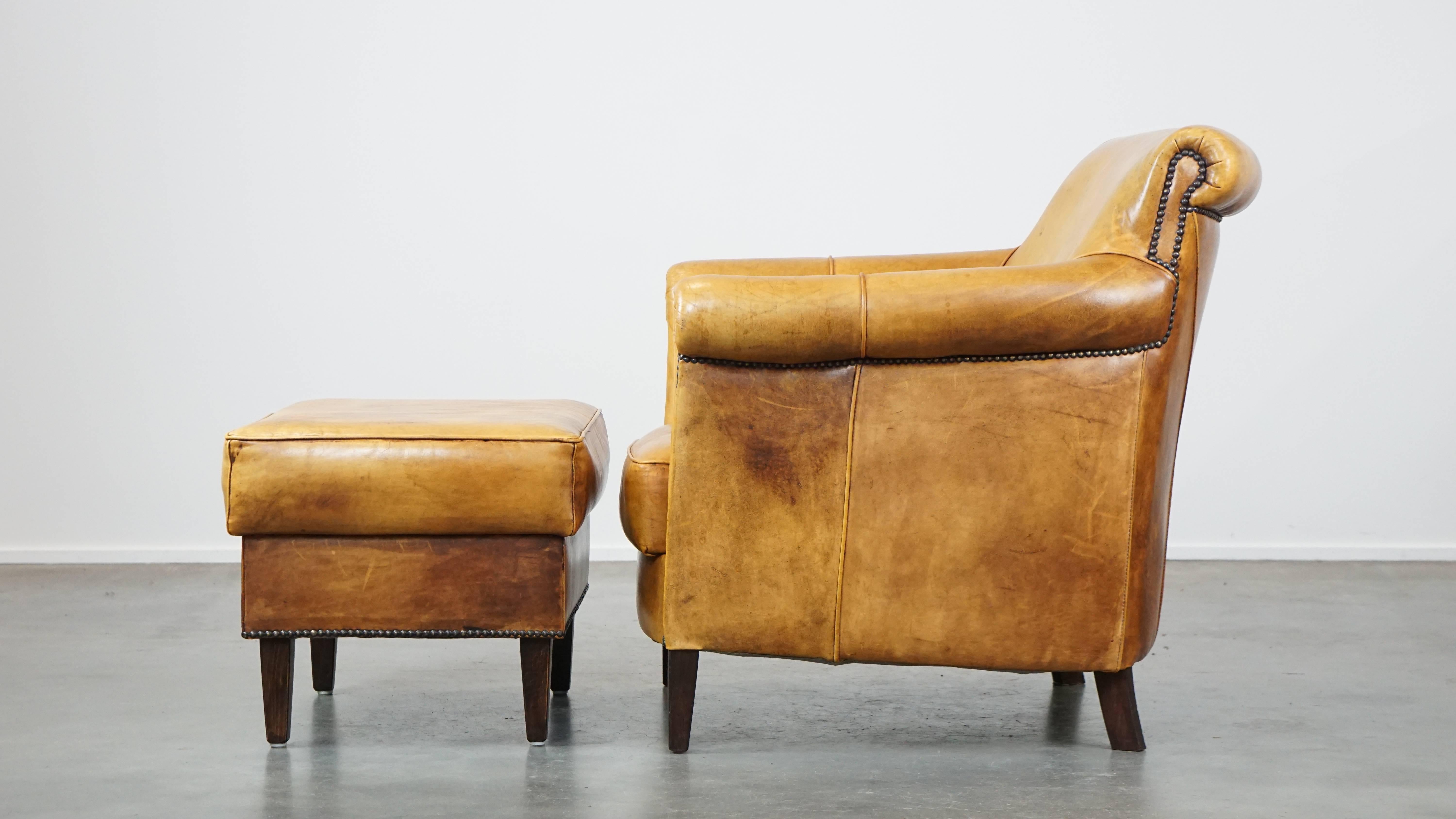 20th Century Comfortable leather armchair with ottoman, finished with decorative nails For Sale