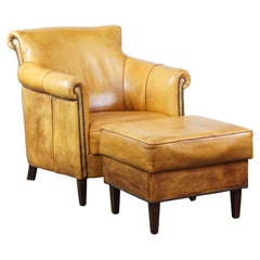 Comfortable leather armchair with ottoman, finished with decorative nails