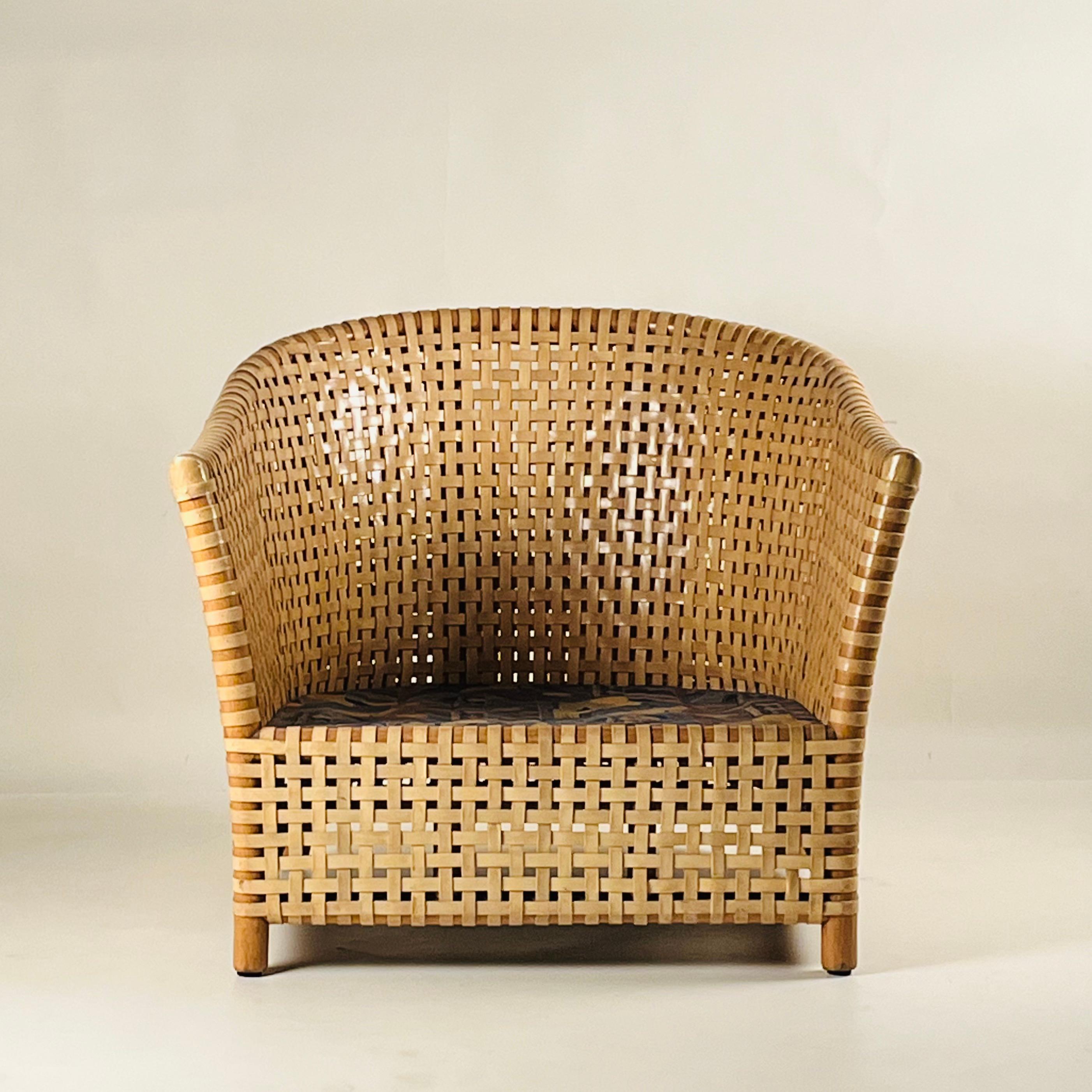 This unique piece features a woven leather strap design that evokes the distinct style of the 1980s. While already comfortable in its current form, it has great potential for new upholstery that will only enhance its appeal. This armchair doesn't