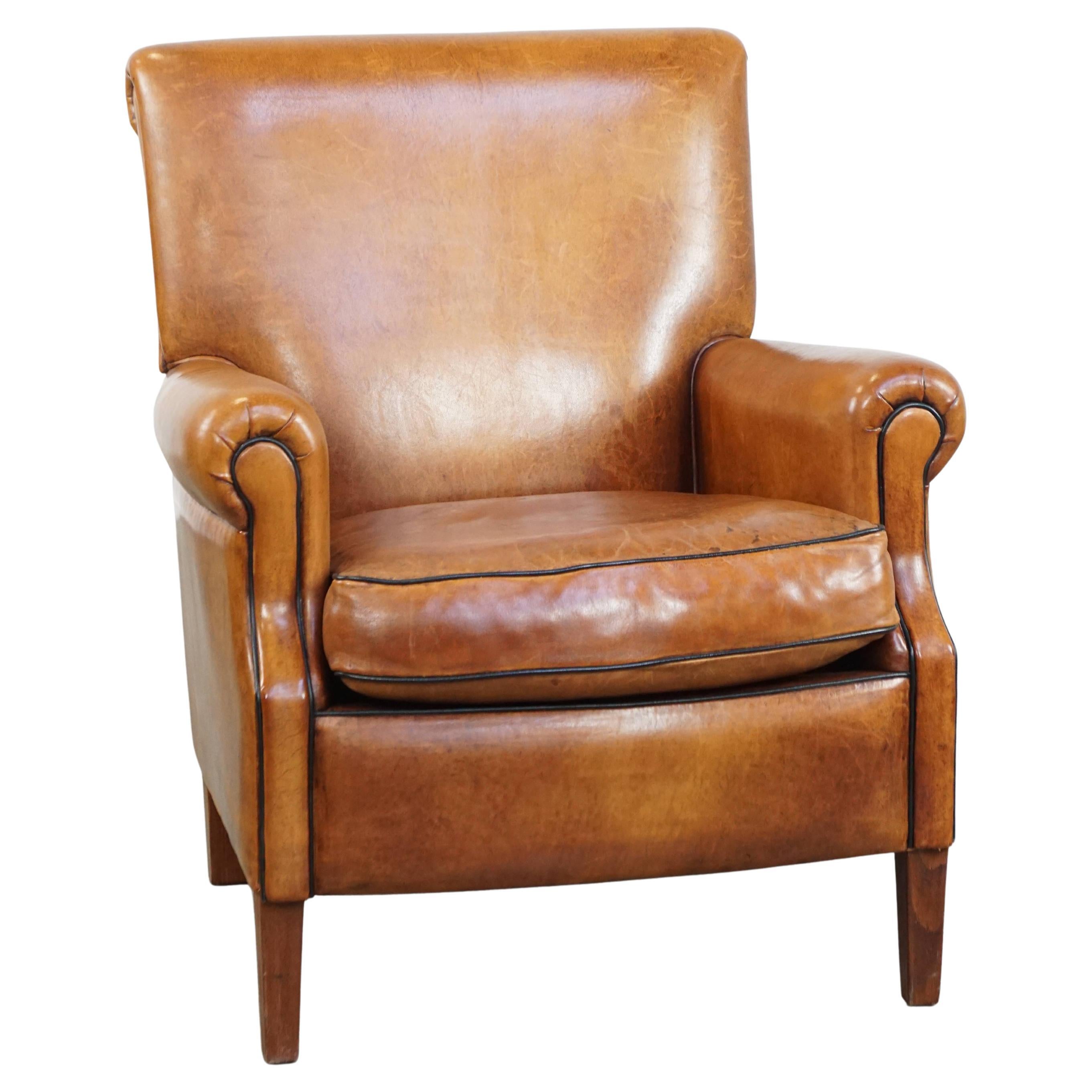 Comfortable, neat sheepskin armchair with sharp black piping, in good condition