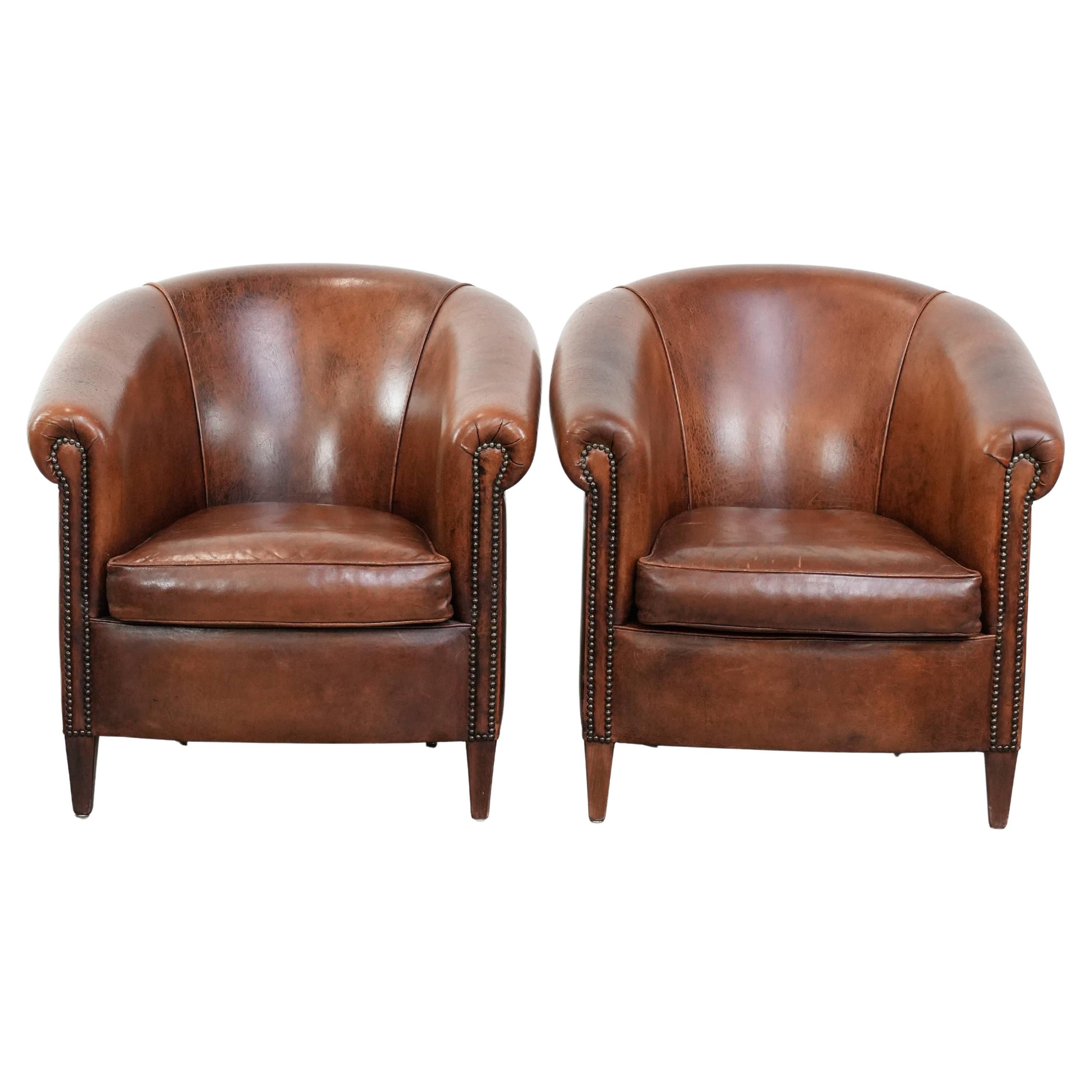 Comfortable set of two sheepskin club chairs with a vintage look