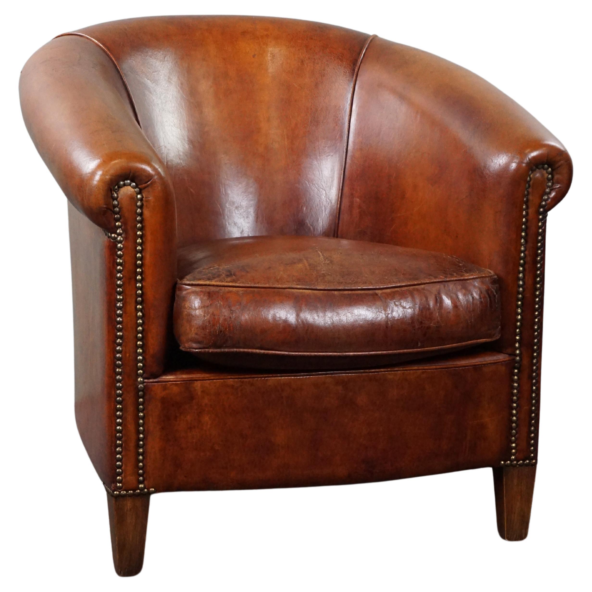 Comfortable sheep leather club armchair in a warm cognac/chestnut color For Sale