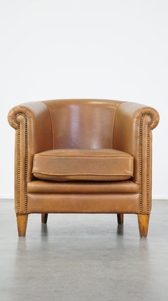 Comfortable sheep leather club chair in cognac color and in good condition