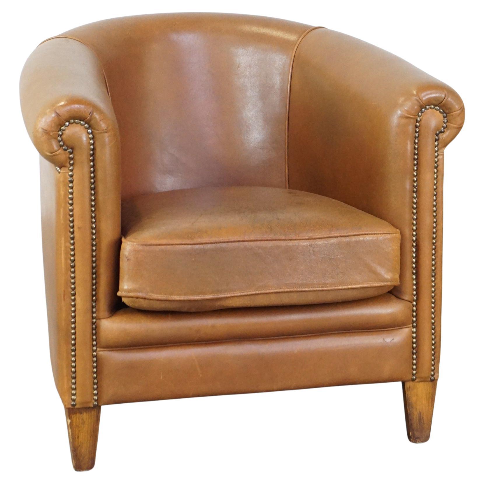 Comfortable sheep leather club chair in cognac color and in good condition