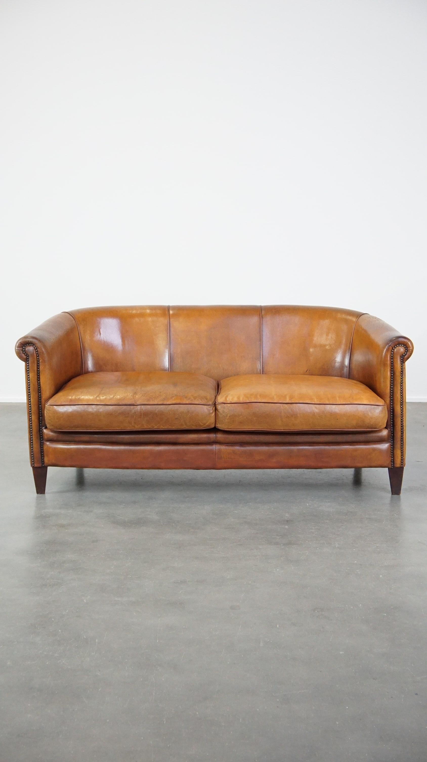 Offered this comfortable 2.5 seater club sofa with a beautiful warm color.

This sofa is one of our favorite items, because it is beautiful in color, has character and is also elegant. The height of the back and armrest are almost the same, which
