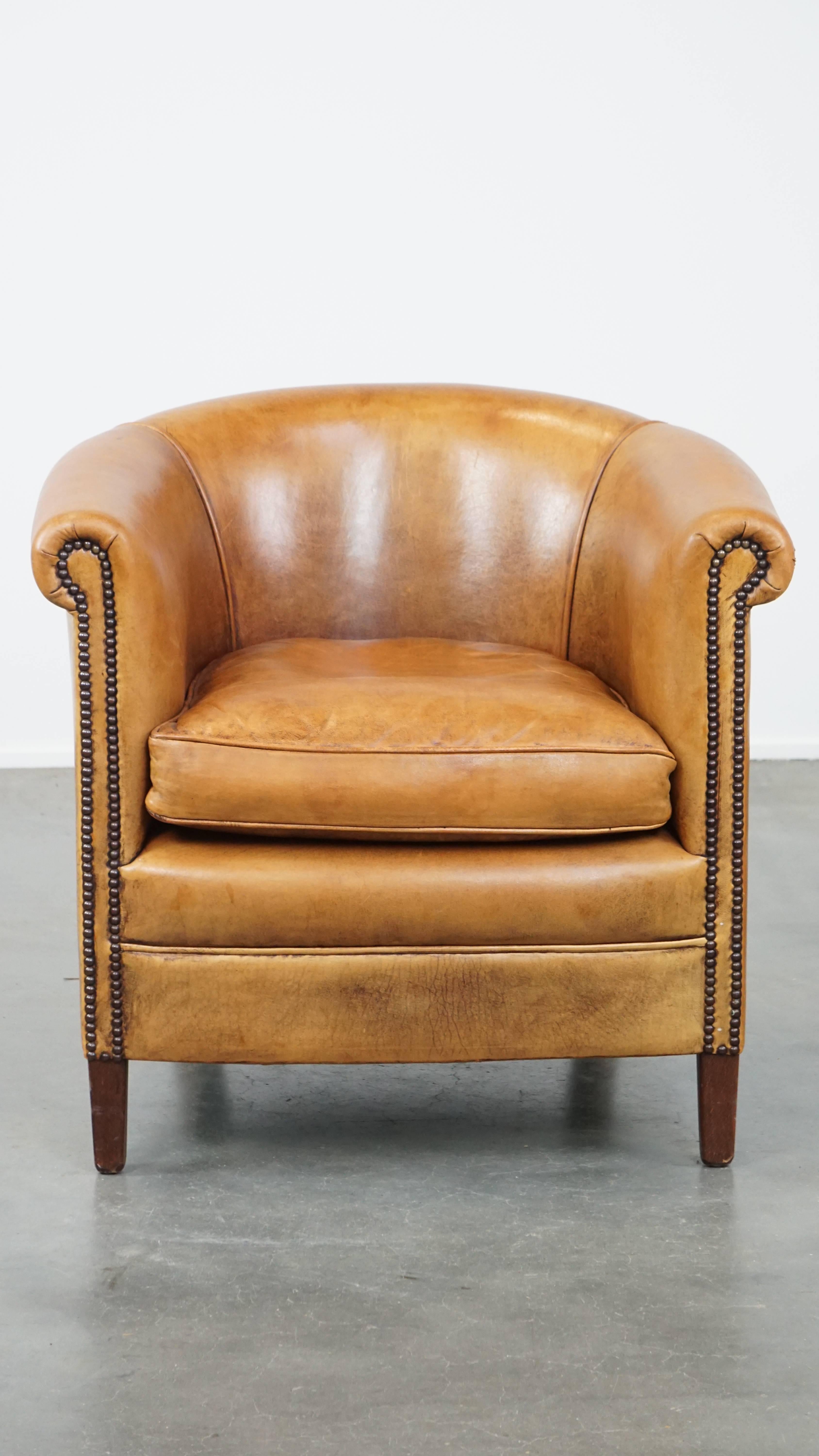 This fantastic club chair, made of sheepskin leather, exudes tranquility and coziness. Its beautiful light cognac color gives it a timeless charm that no one can resist.

The chair is finished with decorative nails and two piping details on the