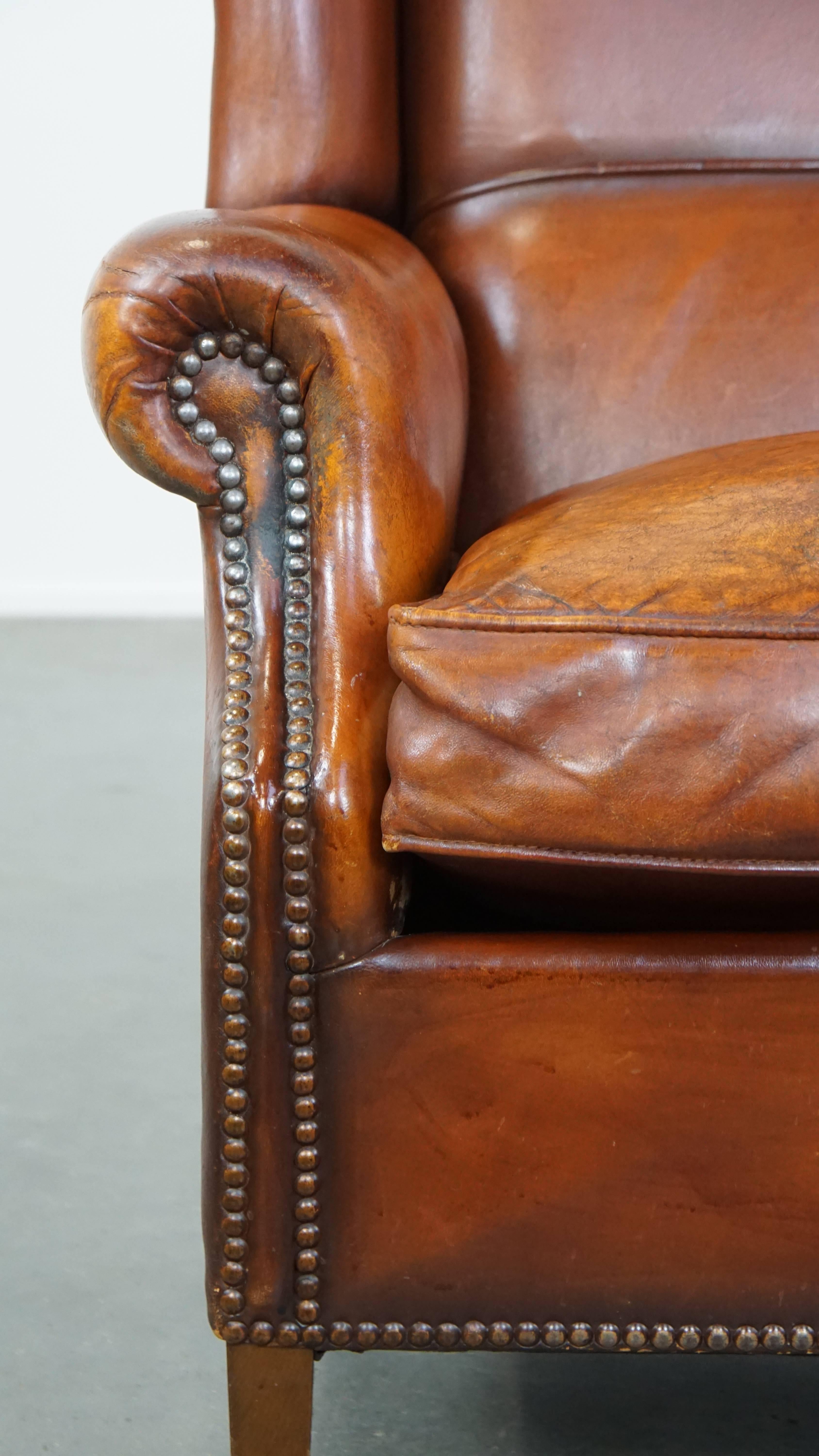 Comfortable sheepskin leather wingback chair with a warm color scheme and patina For Sale 4