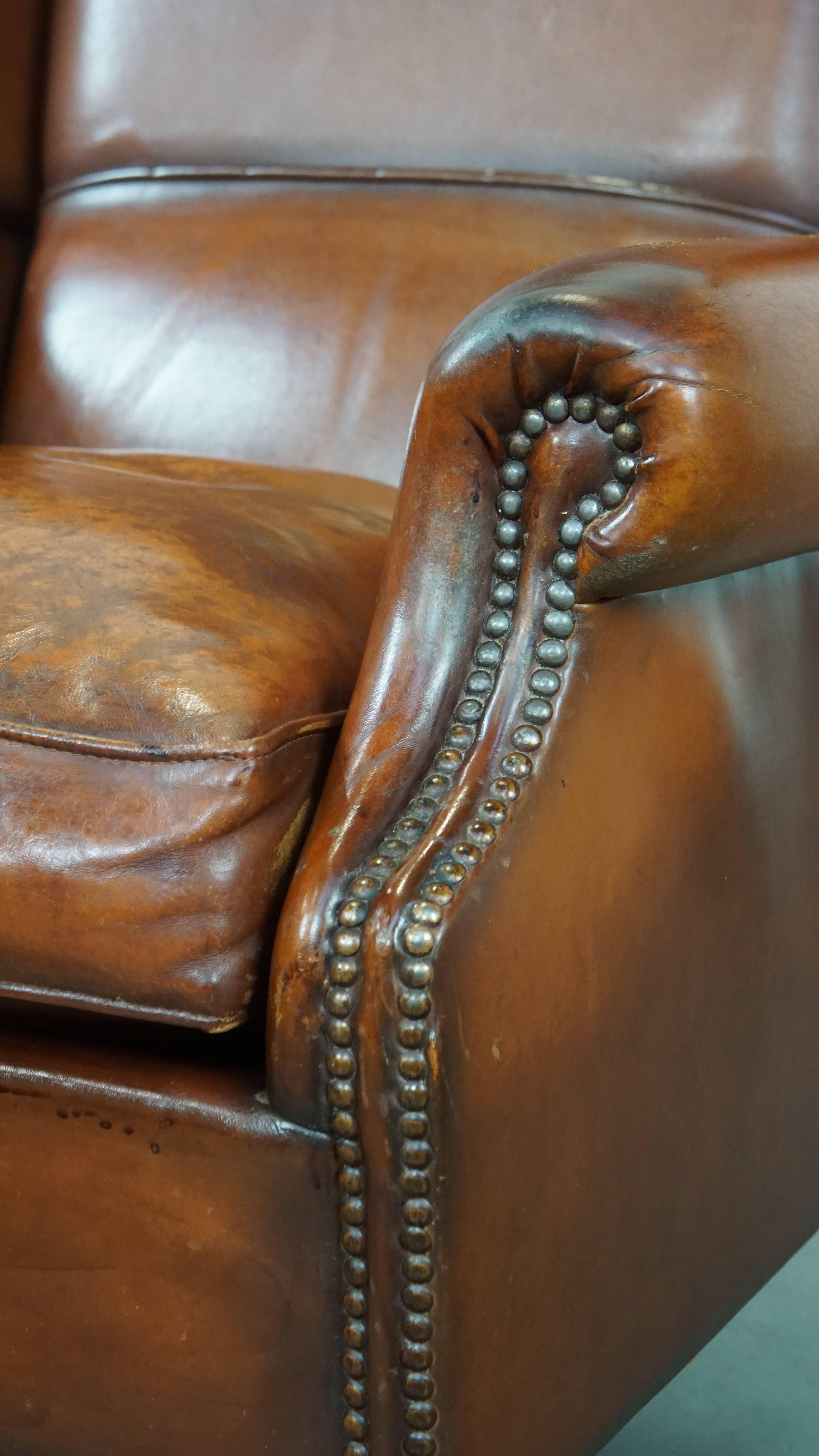 Comfortable sheepskin leather wingback chair with a warm color scheme and patina For Sale 5
