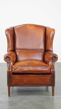 Comfortable sheepskin leather wingback chair with a warm color scheme and patina