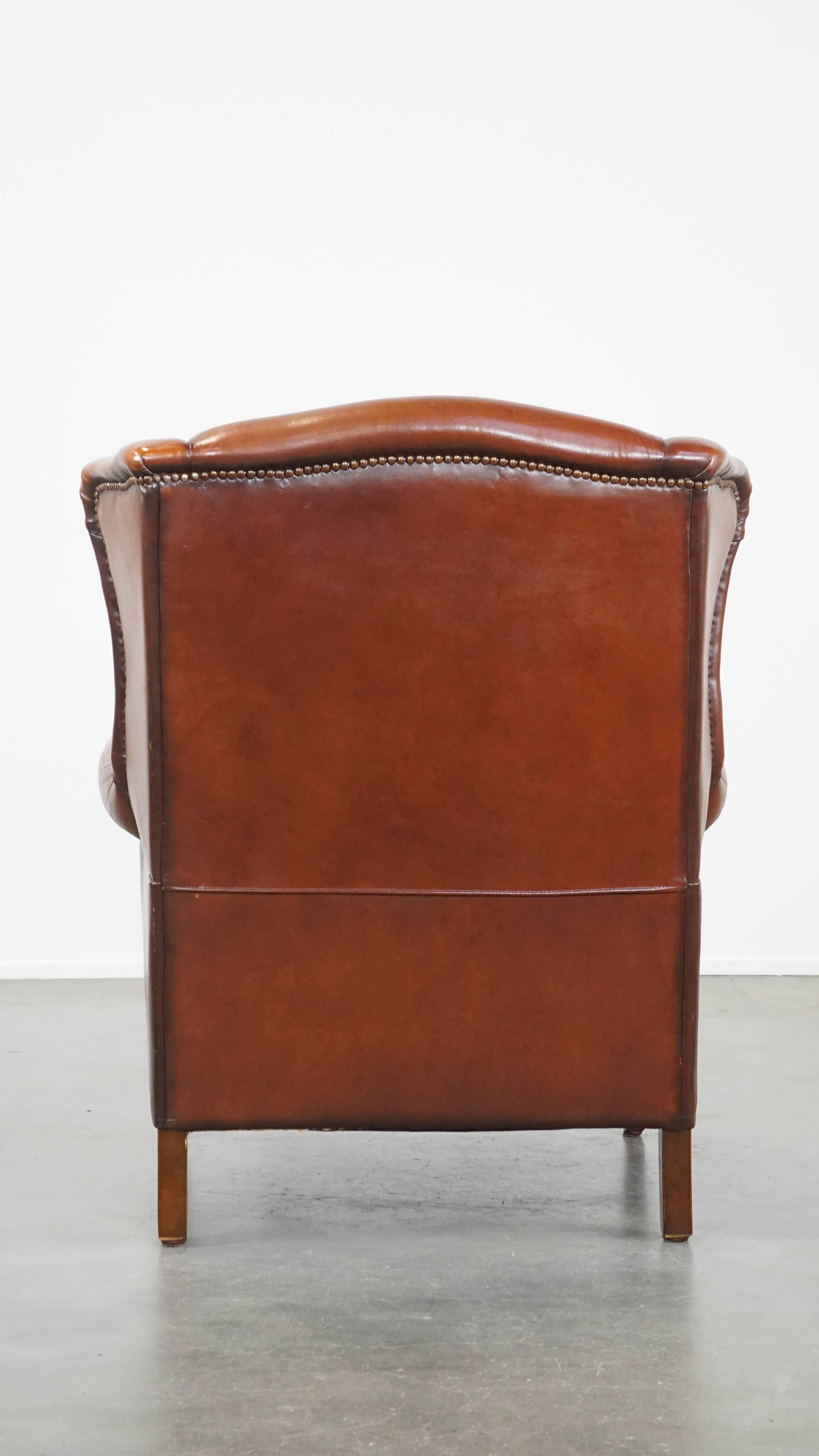 Comfortable sheepskin leather wingback chair with a warm color scheme and patina In Good Condition For Sale In Harderwijk, NL