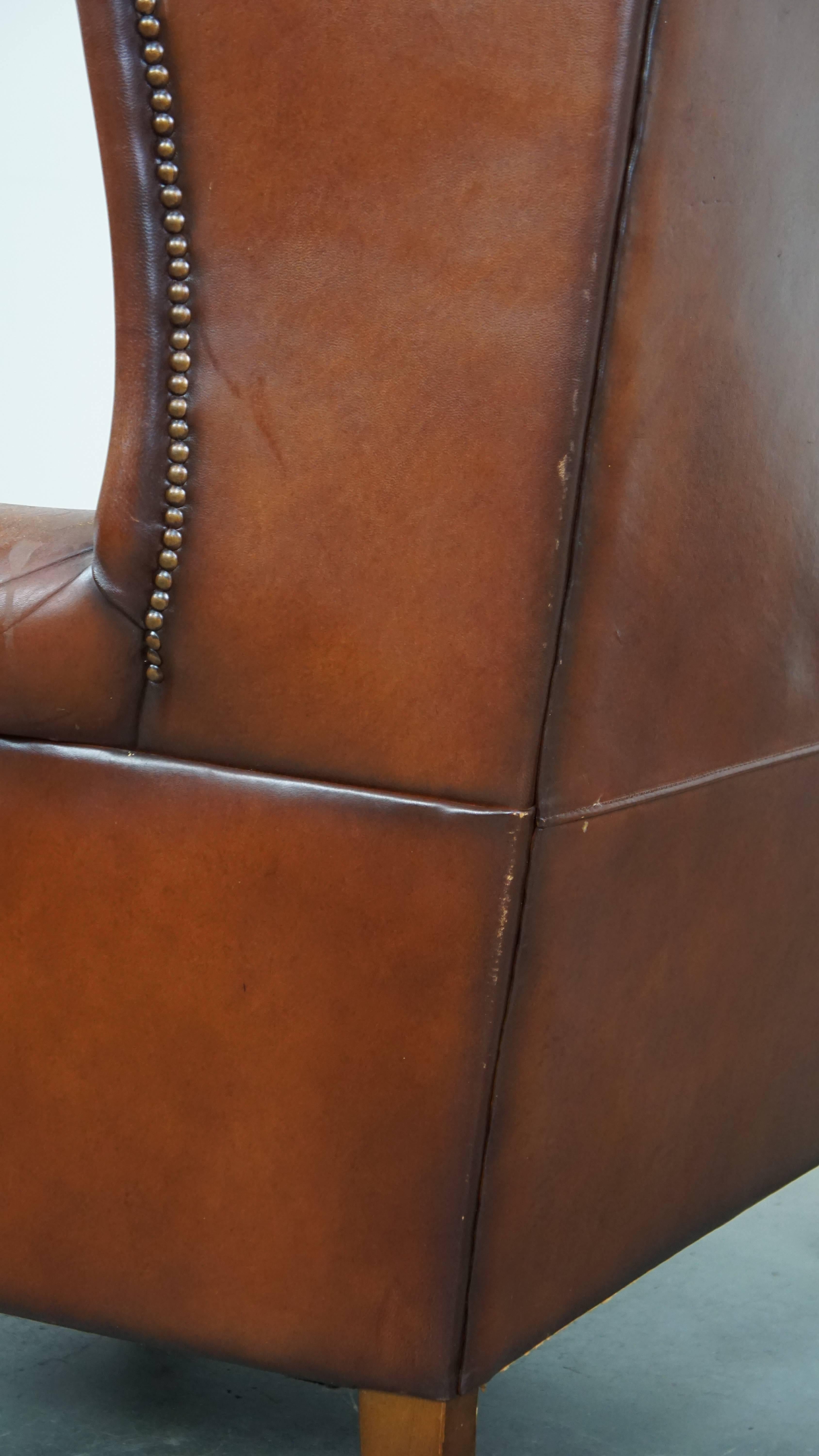 Comfortable sheepskin leather wingback chair with a warm color scheme and patina For Sale 3