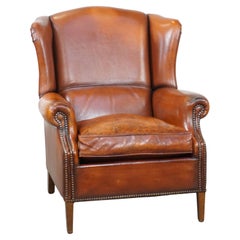 Comfortable sheepskin leather wingback chair with a warm color scheme and patina