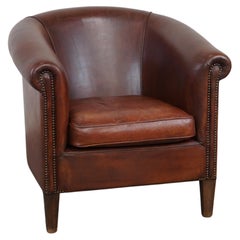 Comfortable spacious sheepskin leather club armchair with a loose seat cushion