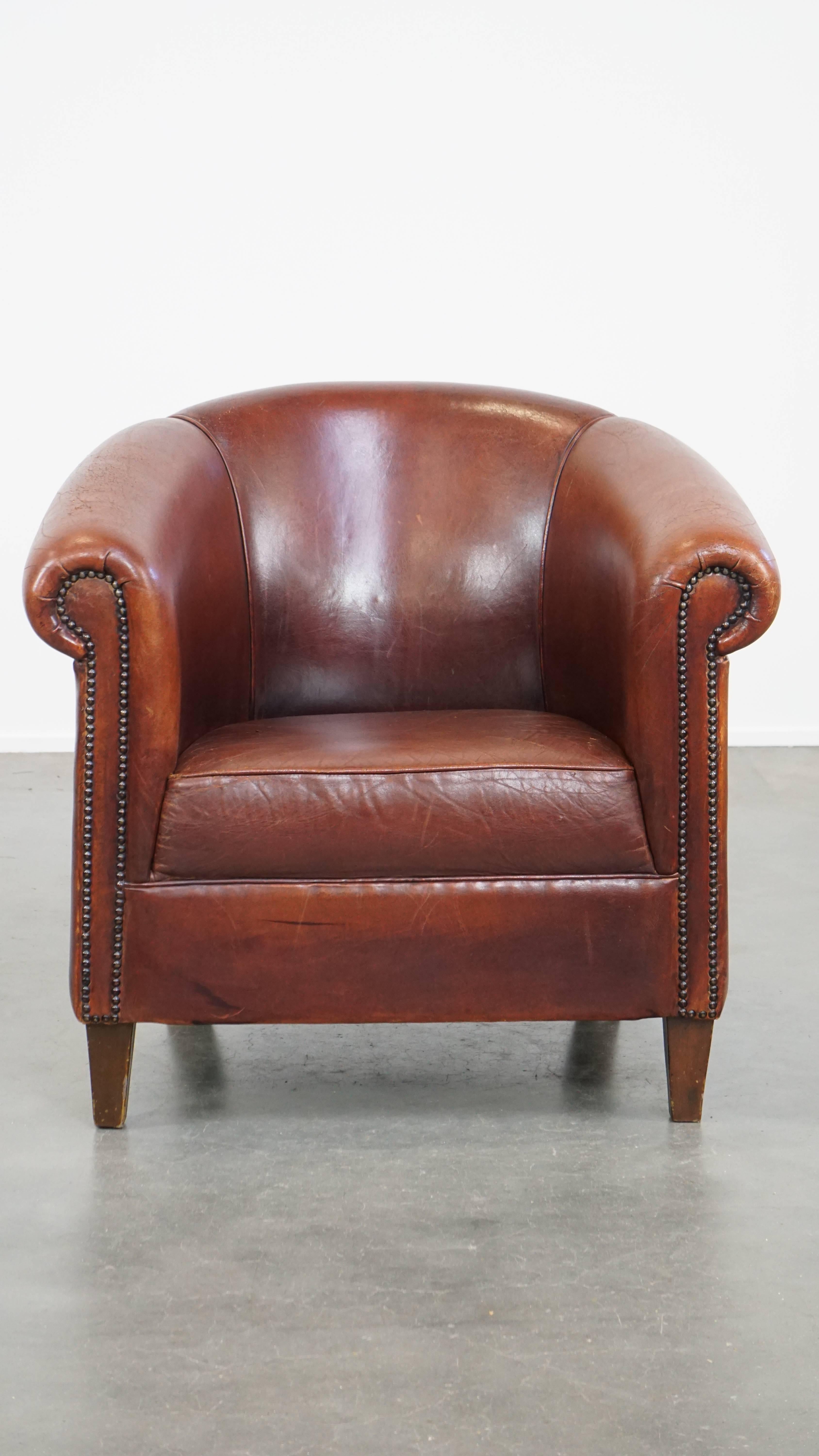 Offered this comfortable vintage sheepskin club chair in English style with a beautiful patina.

This vintage sheepskin club chair contains the ultimate combination of English charm and comfort. Its deep color and timeless design give it a stately,