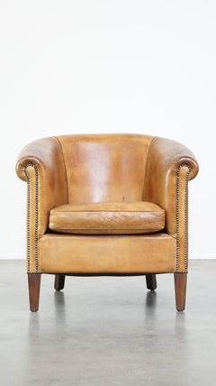 Comfortable, warm colored sheepskin club chair finished with decorative nails