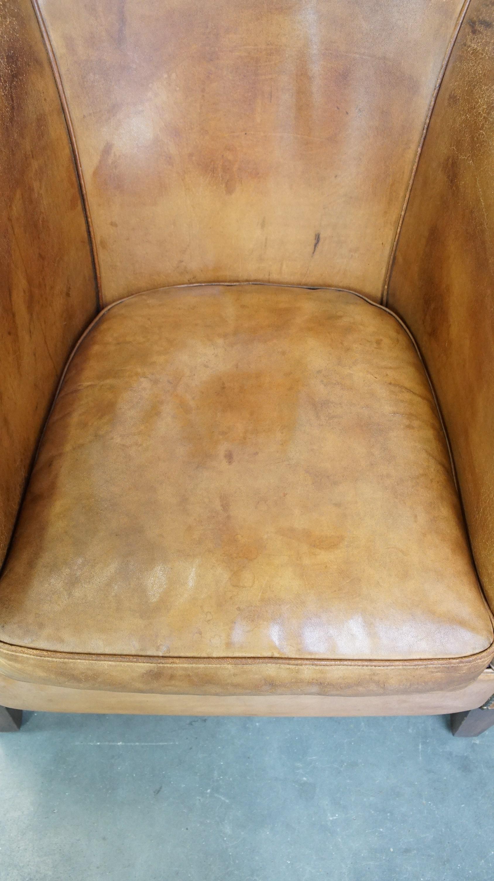 Contemporary Comfortable, warm colored sheepskin club chair finished with decorative nails For Sale