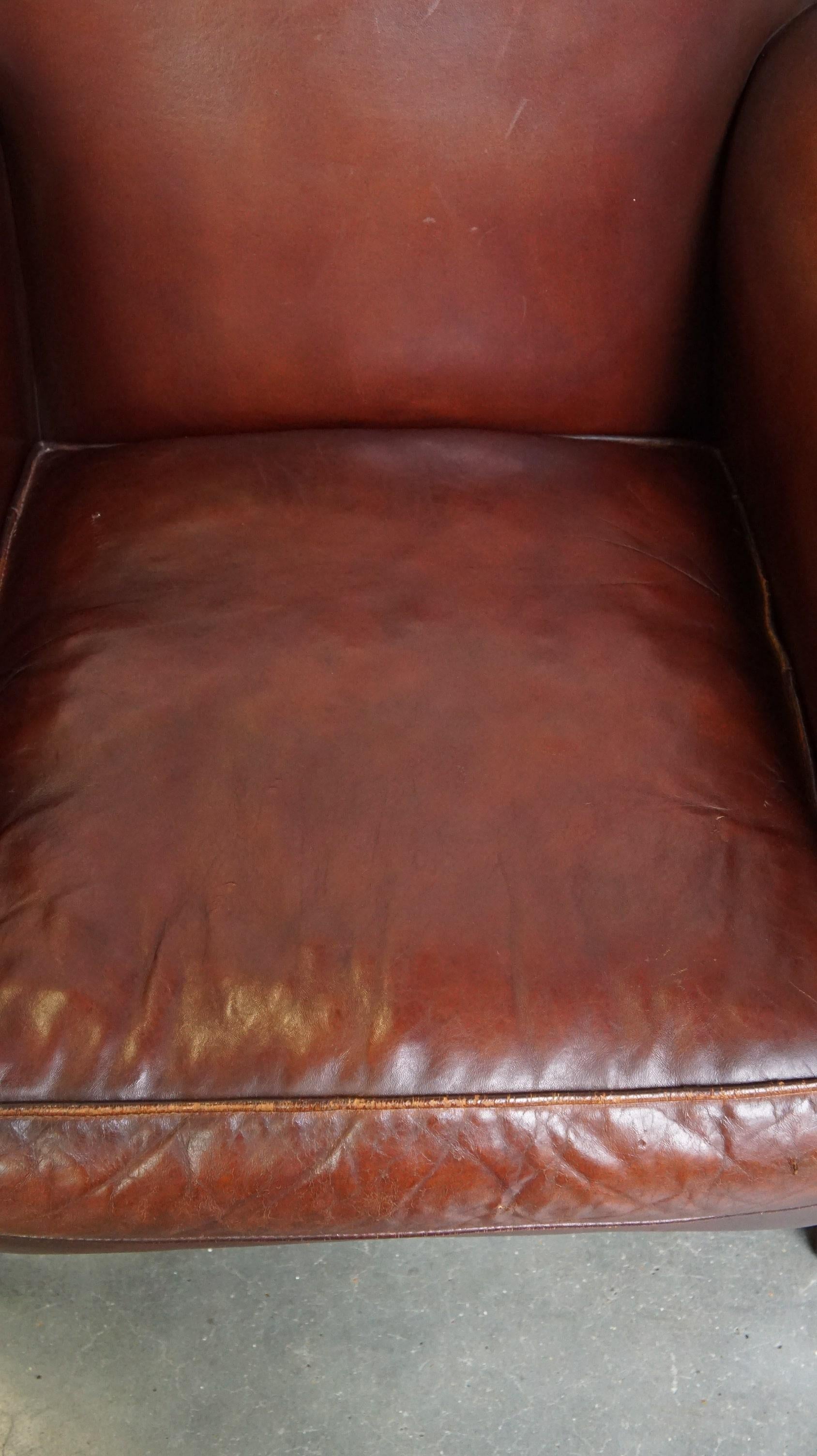 Comfortable, gut verarbeiteter, dunkel lackierter Sessel aus Schafsleder aus Schafsleder (Schaffell und Schafleder) im Angebot