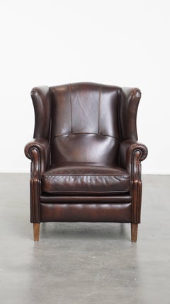 Comfortable wingback chair in English style made of cowhide leather