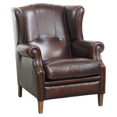 Confortable fauteuil à oreilles de style anglais en cuir de vachette