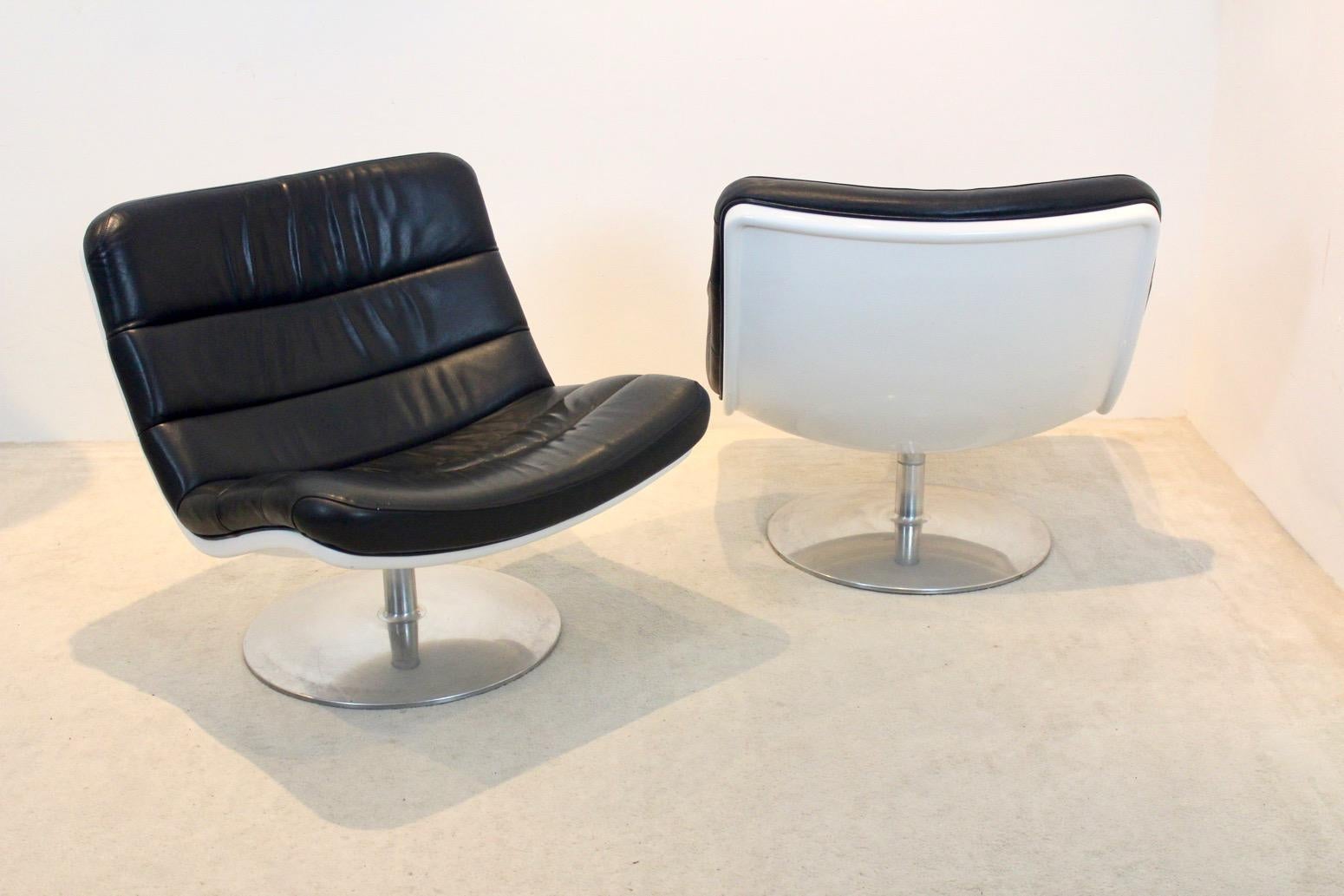 Very comfortable set of lounge chairs designed by Geoffrey Harcourt for Artifort. The chairs have a polished rotating base with a white synthetic shell and black leather seating. The original high quality black leather has a lovely patina. These