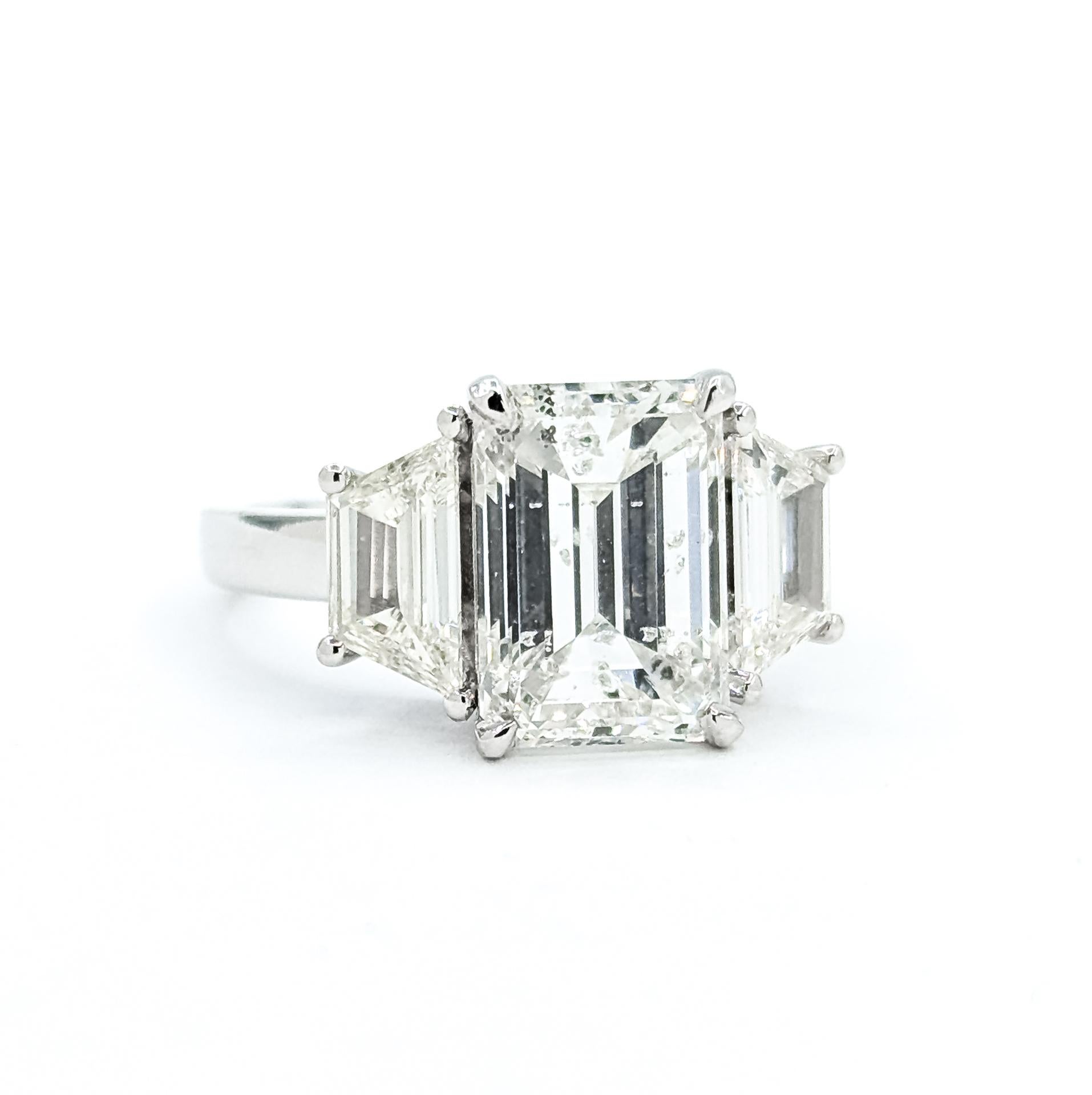 Beherrschender Diamant-Cocktailring mit 3 Steinen aus 18k Weißgold

Dieser auffällige 3-Stein-Cocktailring präsentiert einen Diamanten im Smaragdschliff von 4,07 ct in der Mitte, umrahmt von zwei passenden Diamanten im Trapezschliff von insgesamt