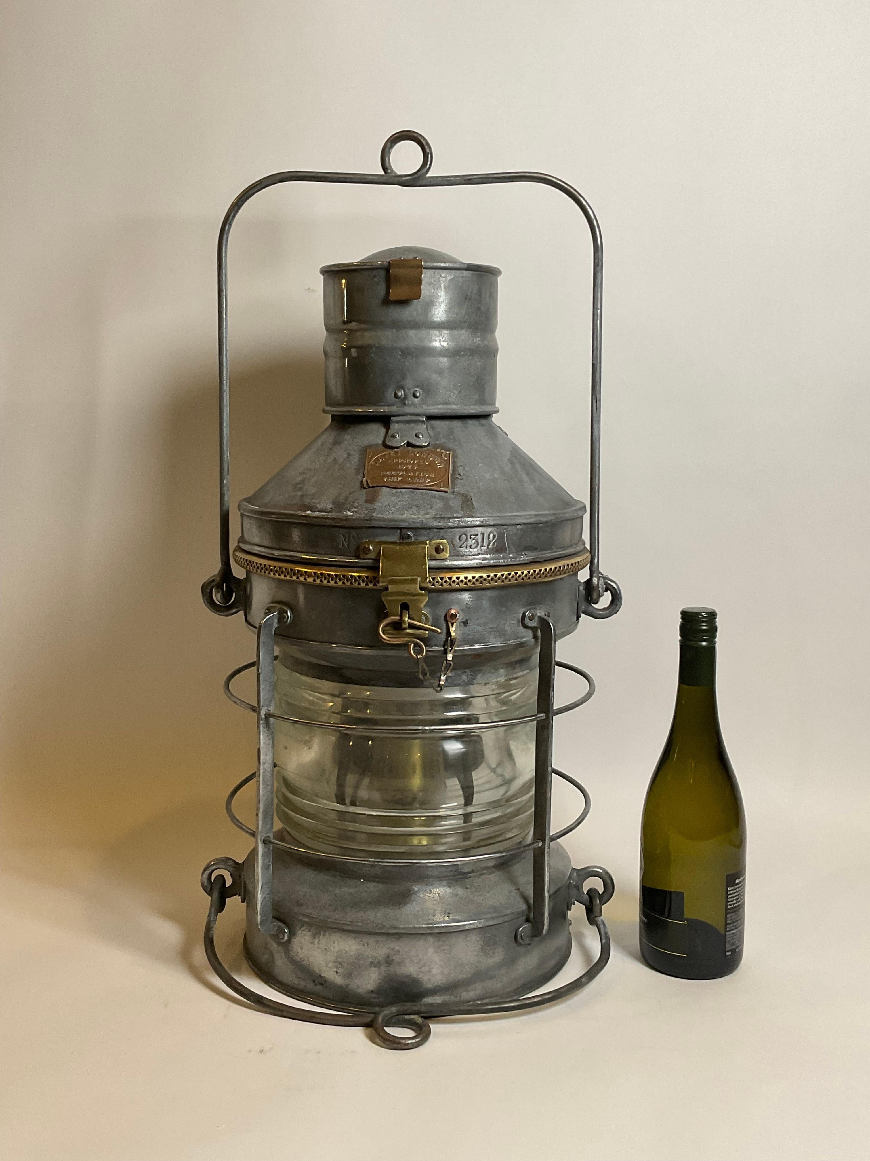 Lantern by the famous English maker Davey of London. With brass makers badge from Davey of London, regulation ship lamp dated 1924. Sturdily Built. Fitted with a Fresnel glass lens and original burner. Fine nautical Antique. Hinge top with brass