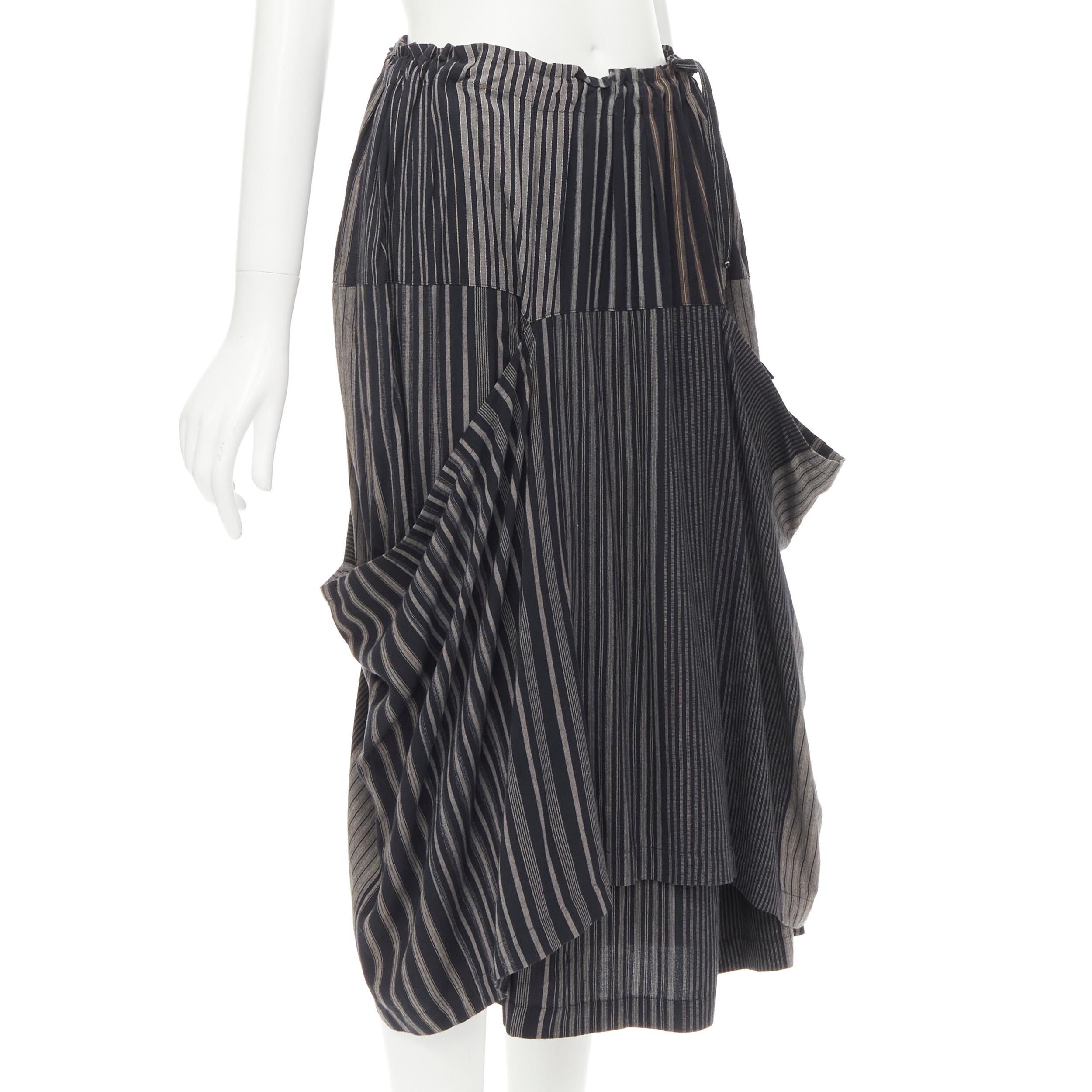 COMME DES GARCONS 1980's Vintage grey stripes deconstructed draped layered skirt 
Reference: CRTI/A00661 
Brand: Comme Des Garcons 
Designer: Rei Kawakubo 
Collection: 1980s 
Material: Cotton 
Color: Grey 
Pattern: Striped 
Extra Detail: Adjustable