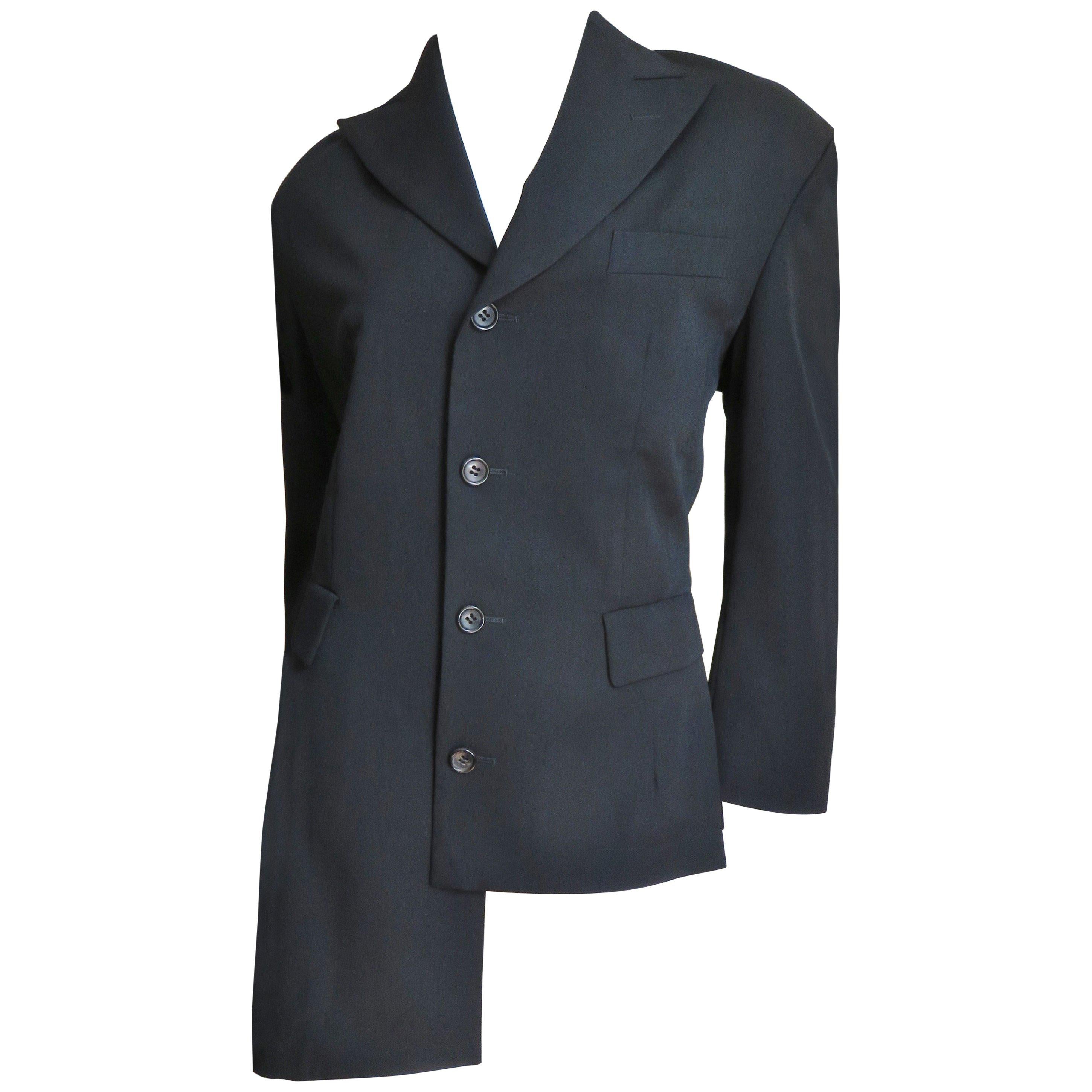 An incredible black light weight wool blazer jacket from Comme des Garcons, CDG.  It has princess seams for a flattering fit, long sleeves, peak lapels, 2 front flap welt pockets and 1 breast pocket.  It is stunning with an asymmetric hemline longer