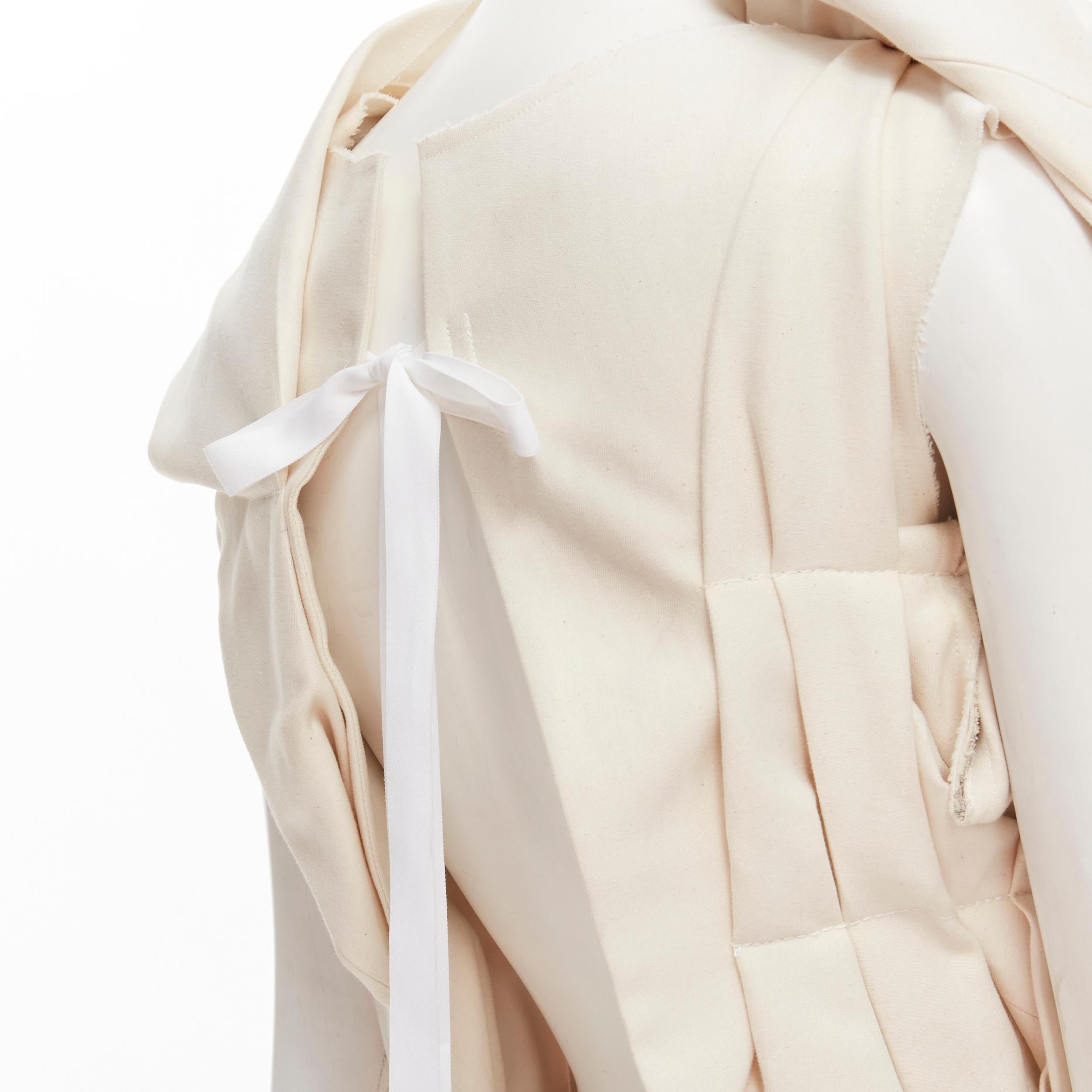 COMME DES GARCONS 2013 Runway beige cotton bundle gathered open tie back top S 
Reference: CRTI/A00692 
Brand: Comme Des Garcons 
Designer: Rei Kawakubo 
Collection: 2013 Runway 
Material: Cotton 
Color: Beige 
Pattern: Solid 
Closure: Tie 
Extra