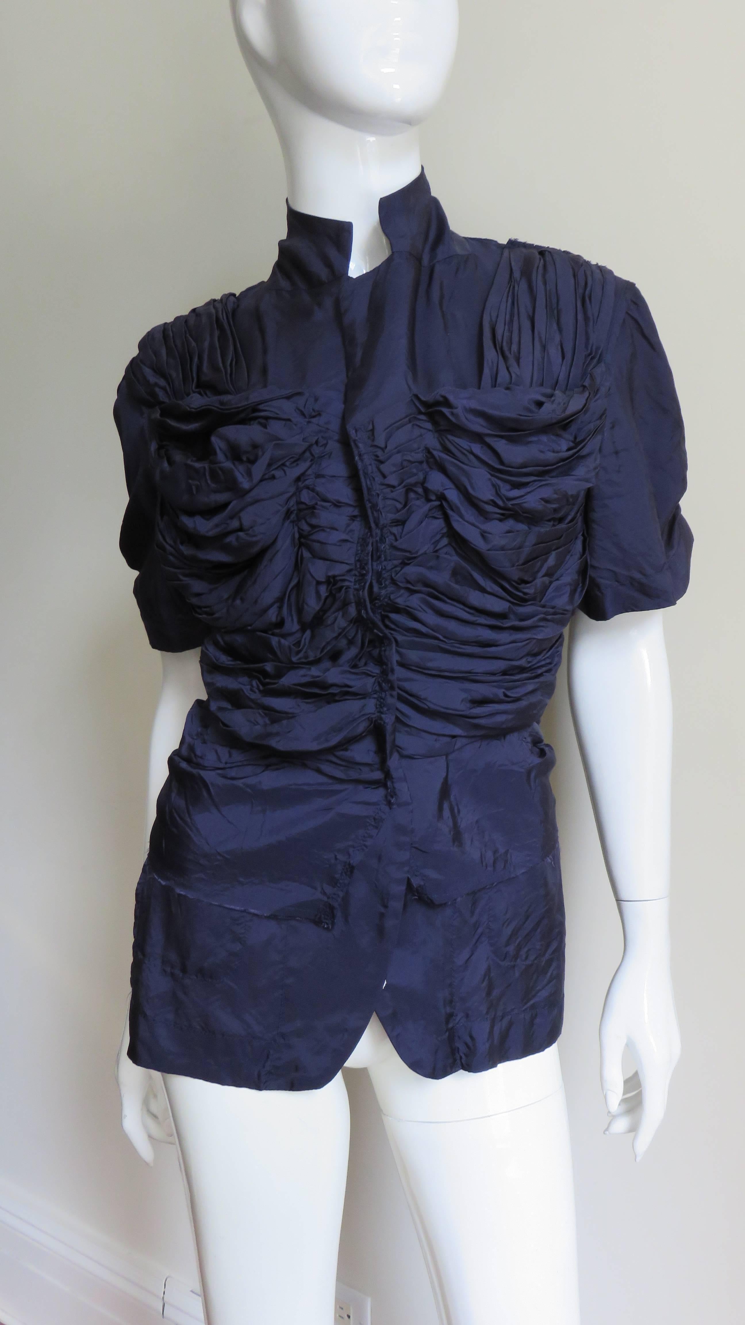 Une belle veste chemise en soie ruchée de couleur violet aubergine de la collection Comme des Garcons, CDG AD 2000.  Elle a des manches courtes, un col à revers convertible qui peut être fermé par des boutons et de nombreux fronces sur le devant qui
