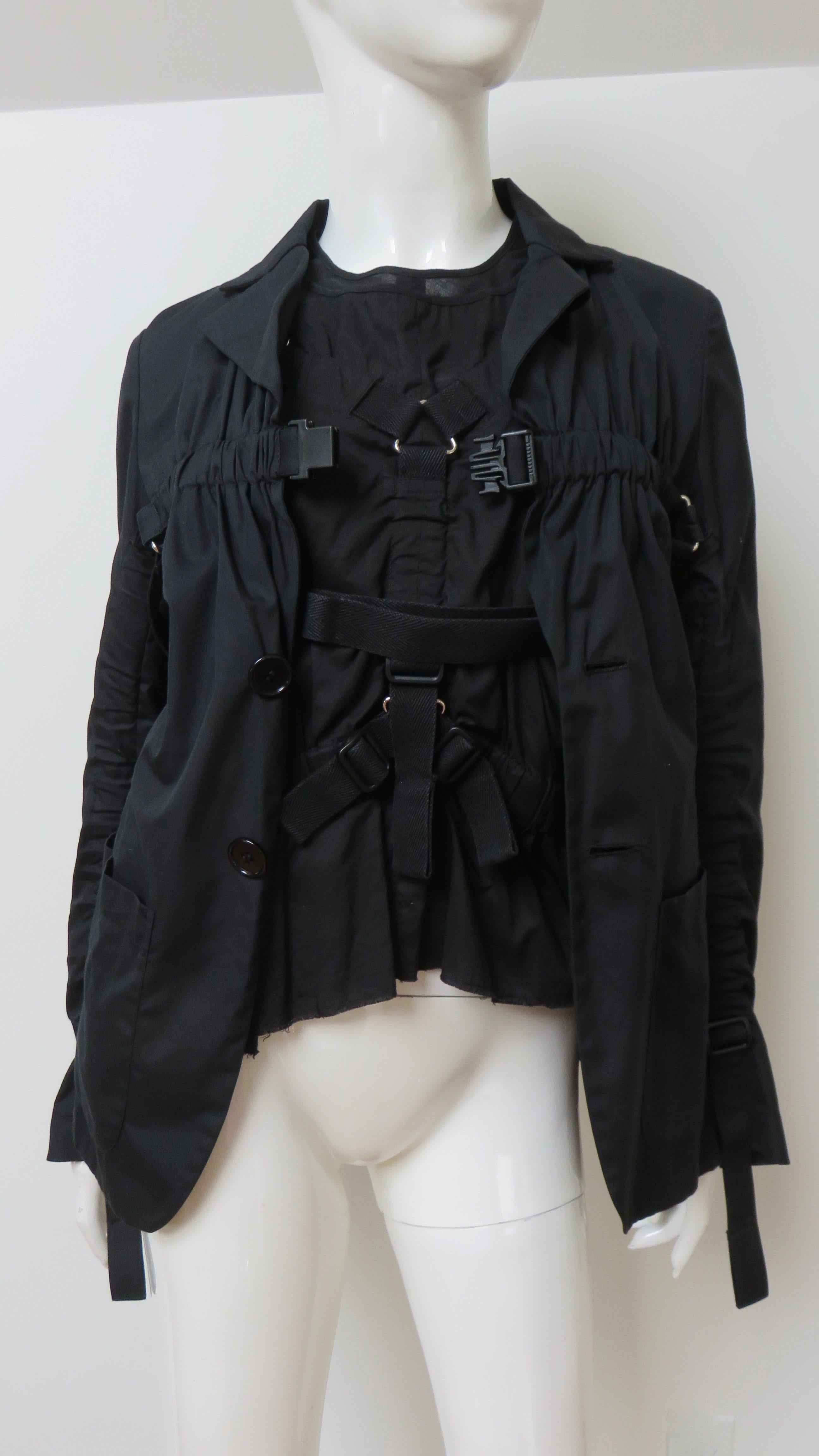 A fabulous black fine cotton 2 piece set consisting of a sleeveless top and matching jacket from Junya Watanabe for Comme des Garcons. The sleeves top has a crew neckline and a configuration of adjustable/moveable straps with buckles attached to