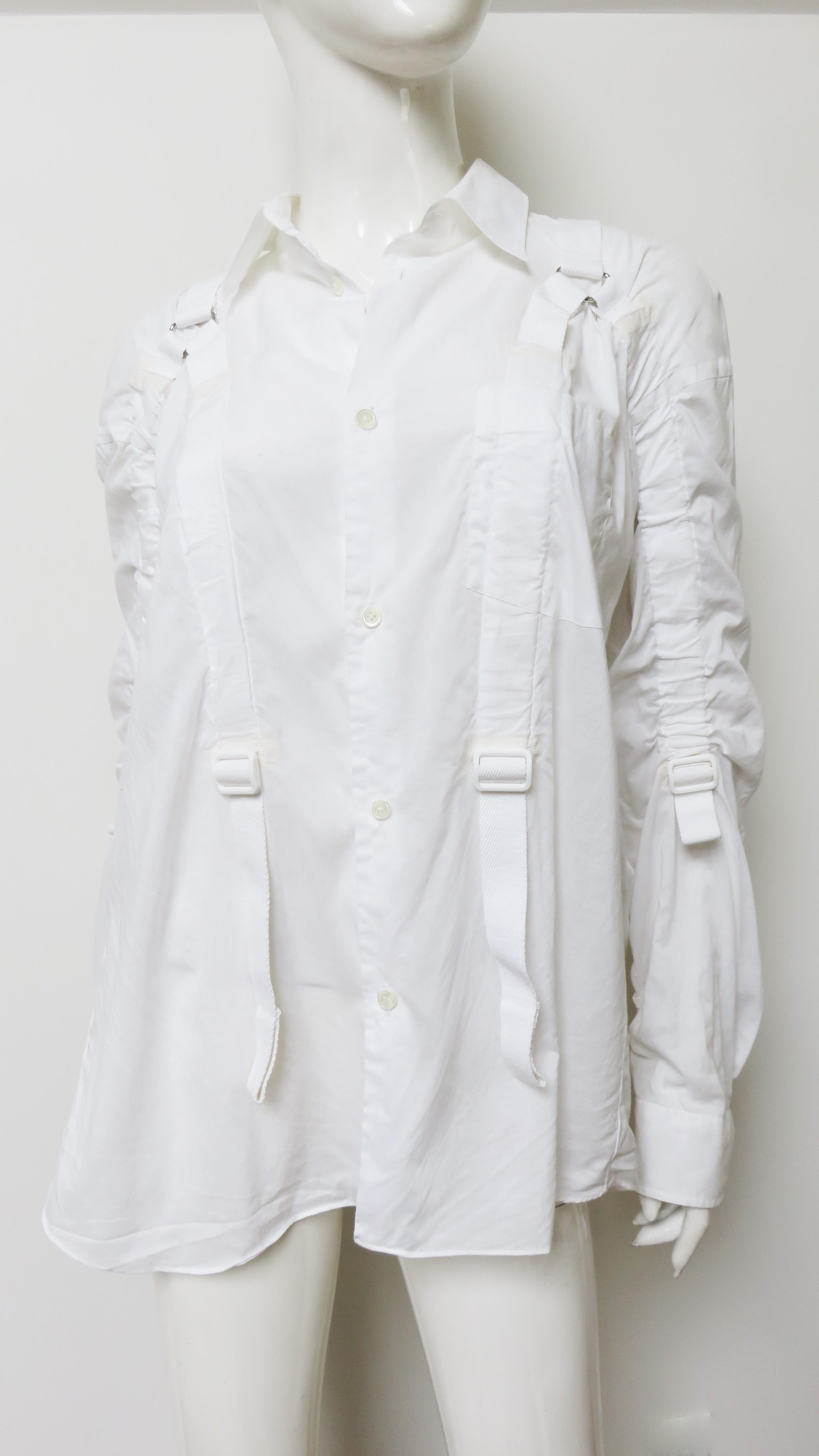 A fabulous fine white cotton shirt from Junya Watanabe for Comme des Garcons (CDG).  It has a shirt collar, long cuff sleeves and mother of pearl buttons up the front. The back fuller than the front has an opening under the yoke with a full gathered