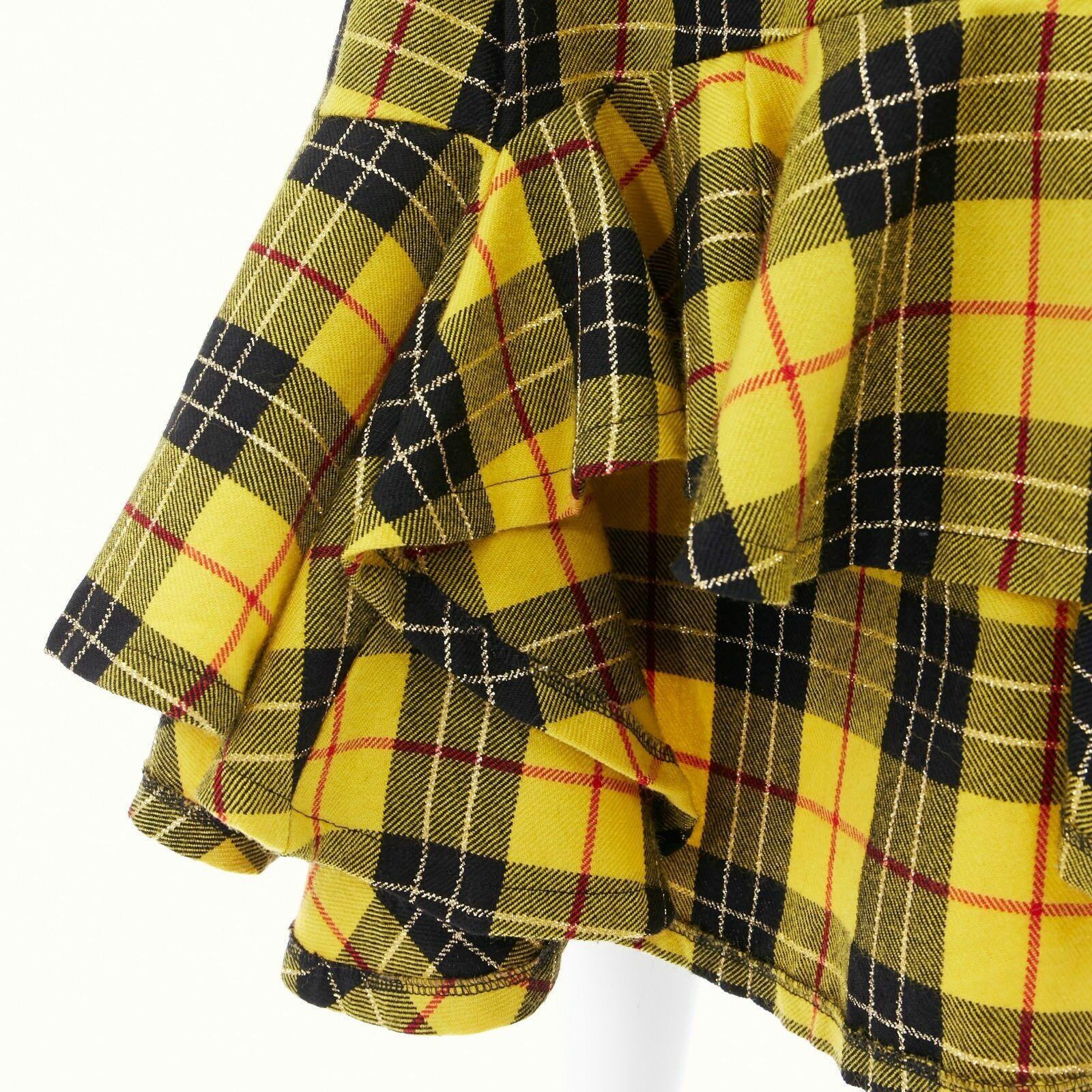 COMME DES GARCONS AW99 punk yellow tartan plaid ruffle hem layered wrap skirt M
COMME DES GARCONS
FROM THE FALL WINTER 1999 COLLECTION
100% wool. Yellow black punk-inspired plaid tartain wool. 
Dual layered. Self wrap around skirt . 
Comes with