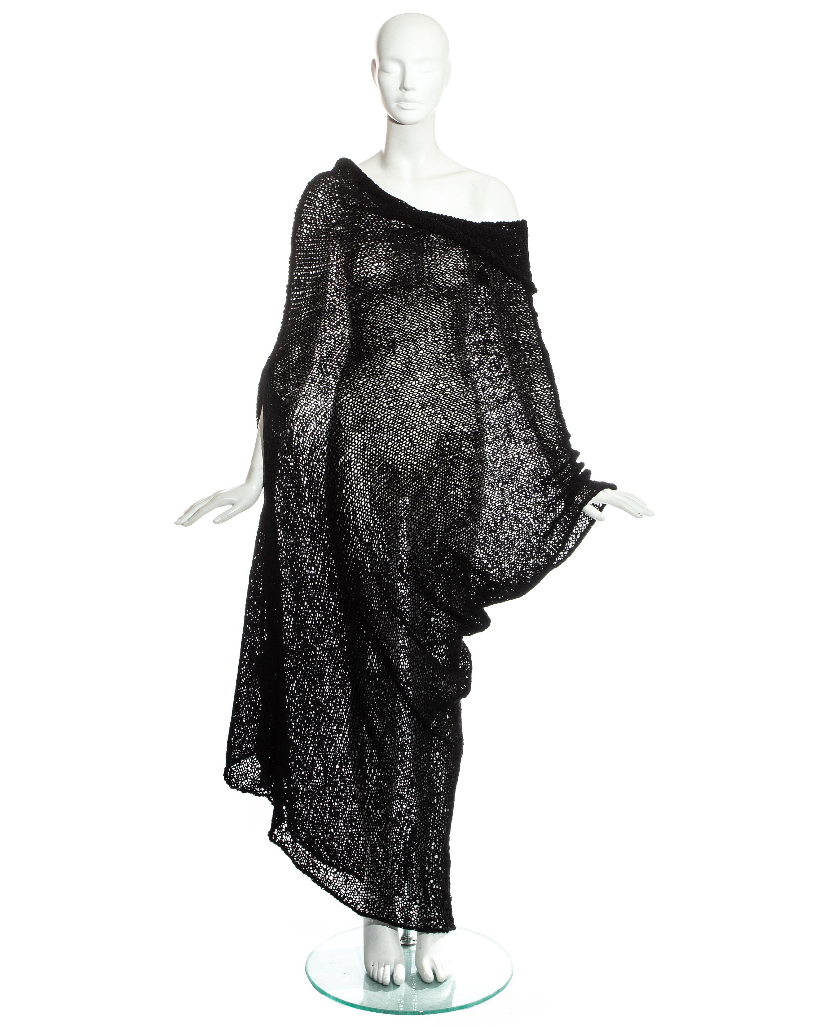 Comme des Garcons; black knitted raw silk dress. L-shaped, with elongated panel forming a cowl collar, slits for the arms and diagonal hem. Can be worn right side up or upside down.   

'Tricot - Hand Made' label   

Spring-Summer 1984 