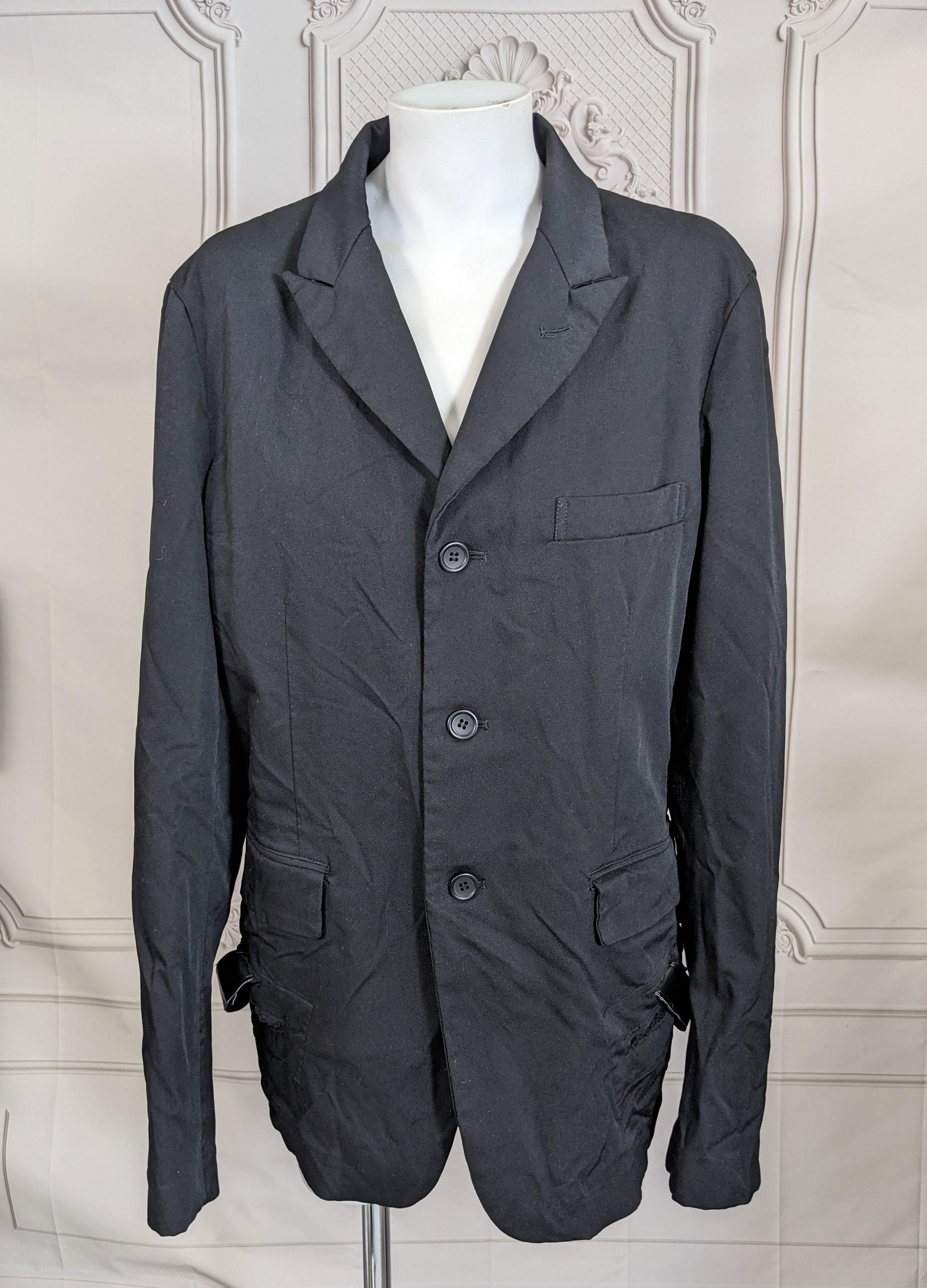 Blazer Comme des Garcons BLACK Bondage con lazada lateral oculta a la vista frontal. Subversivo a la manera de CDG, donde una americana arrugada clásica cambia cuando se ve desde distintos ángulos. A cada lado hay correas de piel sintética con