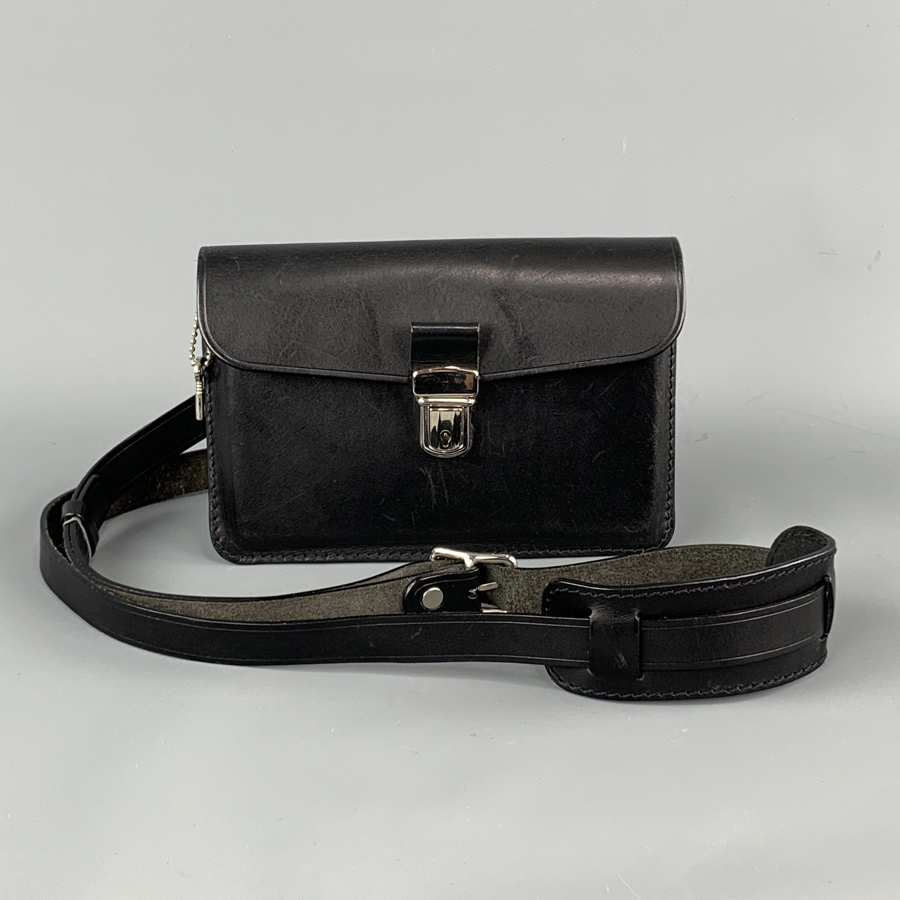 COMME des GARCONS mini satchel bag comes in structured black leather with a flap press lock closure, top zip, and back loops for belt attachment or detachable strap. Minor wear.
 
Very Good Pre-Owned Condition.
 
Measurements:
 
Length: 8 in.
Width:
