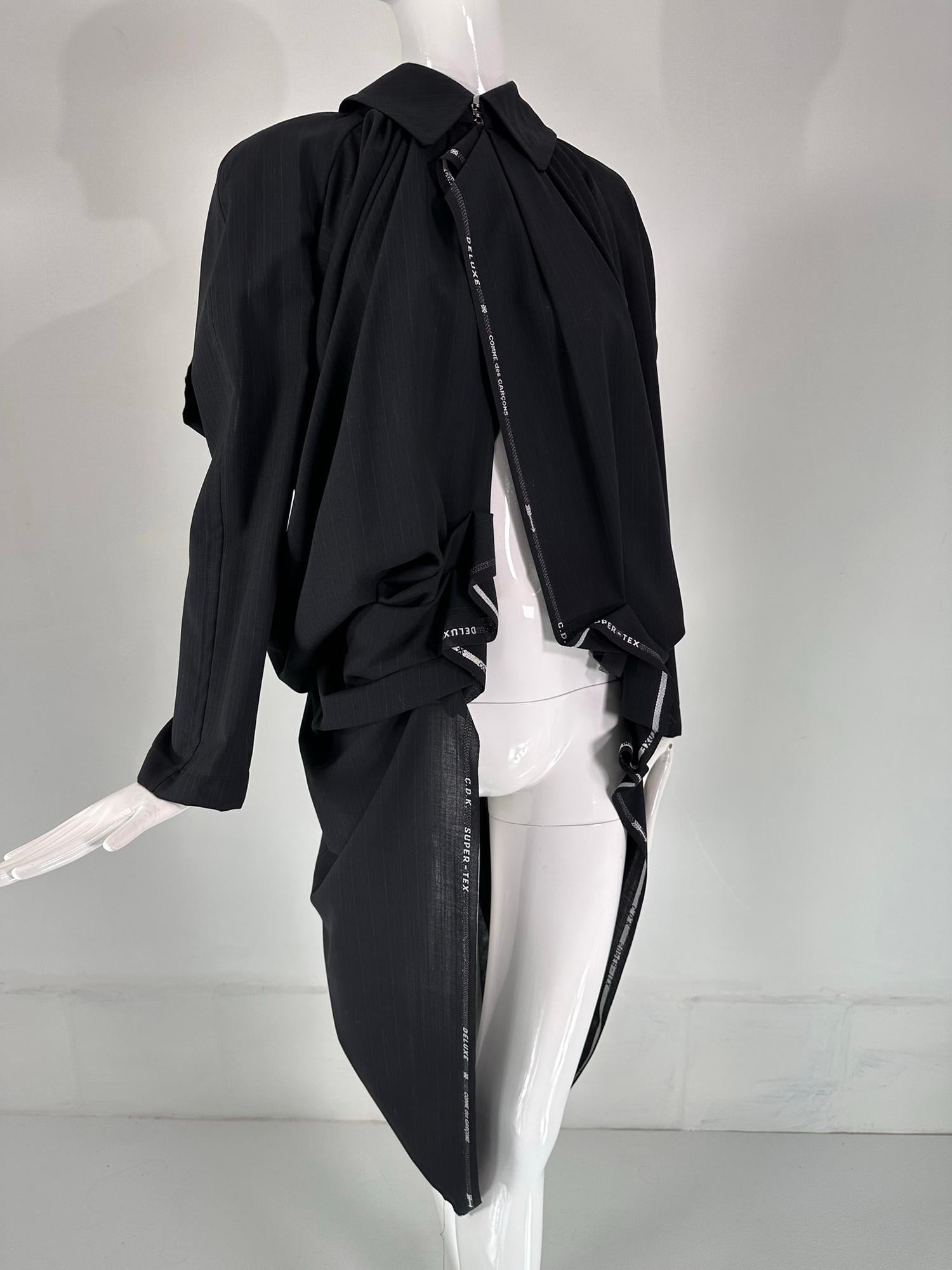 Comme Des Garçons deconstructed black wool blend pin stripe cape/coat 2005. Cocoon shape with collar that closes at the neck front with double silver hook & eyes. Long sleeves are attached at the shoulder front edges but are open at the back.  Woven