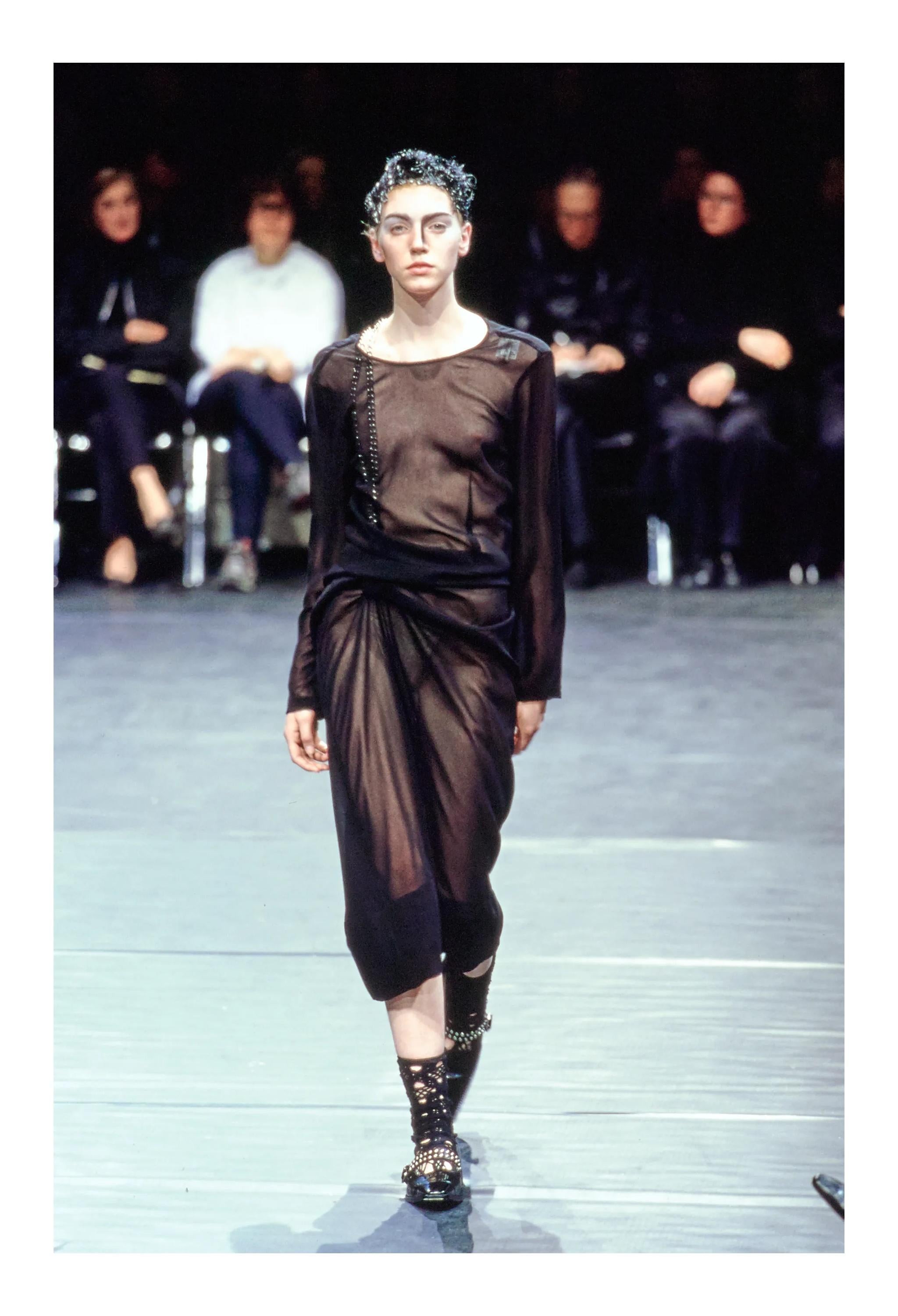 Resurrection Vintage a le plaisir de vous proposer une robe vintage Comme des Garçons en voile noir avec drapé et chaînes intérieures argentées de la collection Automne 2000, avec une doublure amovible, des manches longues, des chaînes intérieures