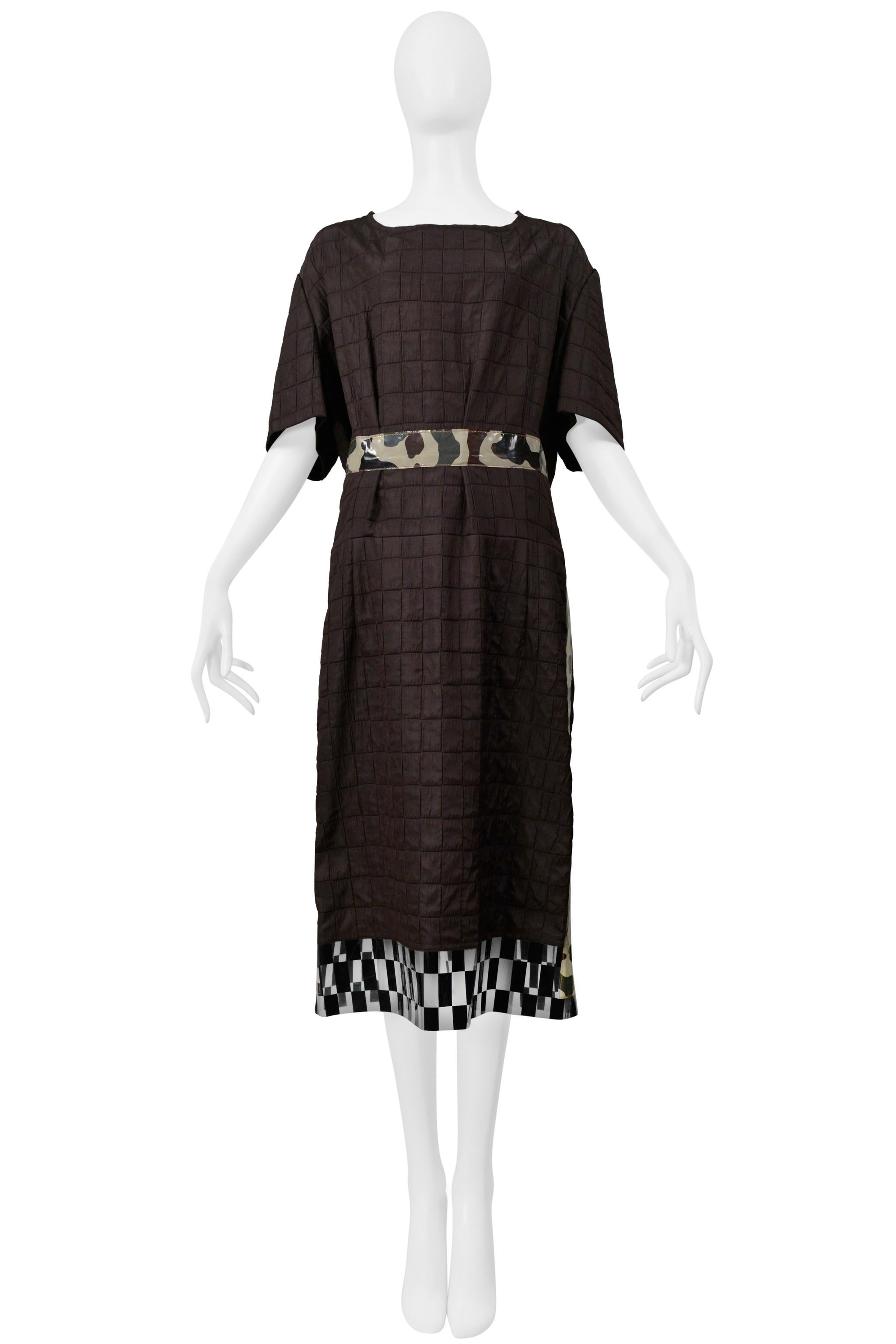Resurrection Vintage está encantada de ofrecer un vestido de día vintage Comme des Garçons marrón con ribete de camuflaje y ribete de vinilo a cuadros, con efecto acolchado, cuello barco, mangas anchas, corte fácil y largo por debajo de la
