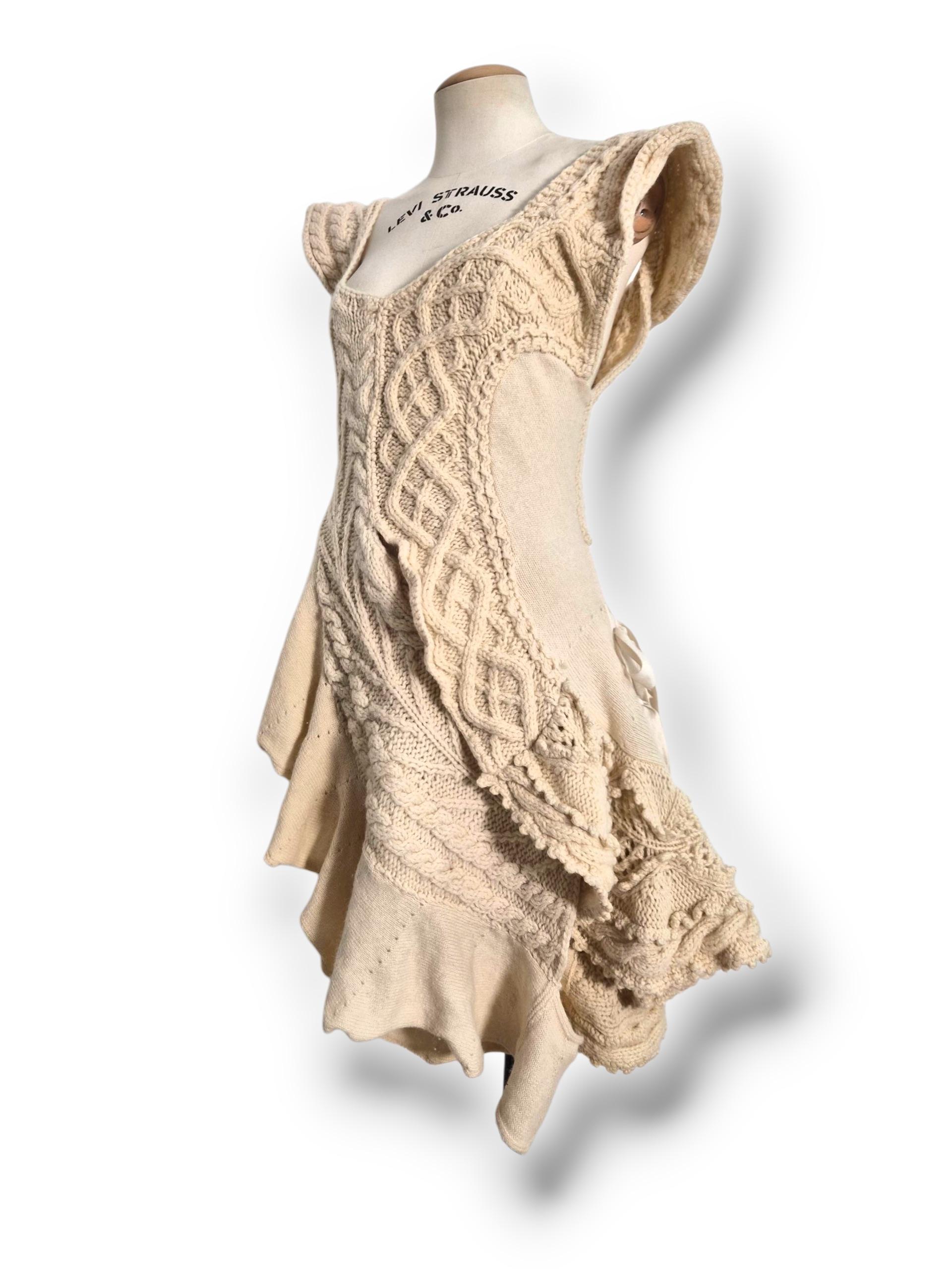 Cette robe Comme des Garçons by Tao est une fusion sculpturale de crochet à la main et de laine finement tricotée, conçue dans une silhouette organiquement drapée qui capture l'esprit artisanal de la collection 2007. Confectionné en douce laine