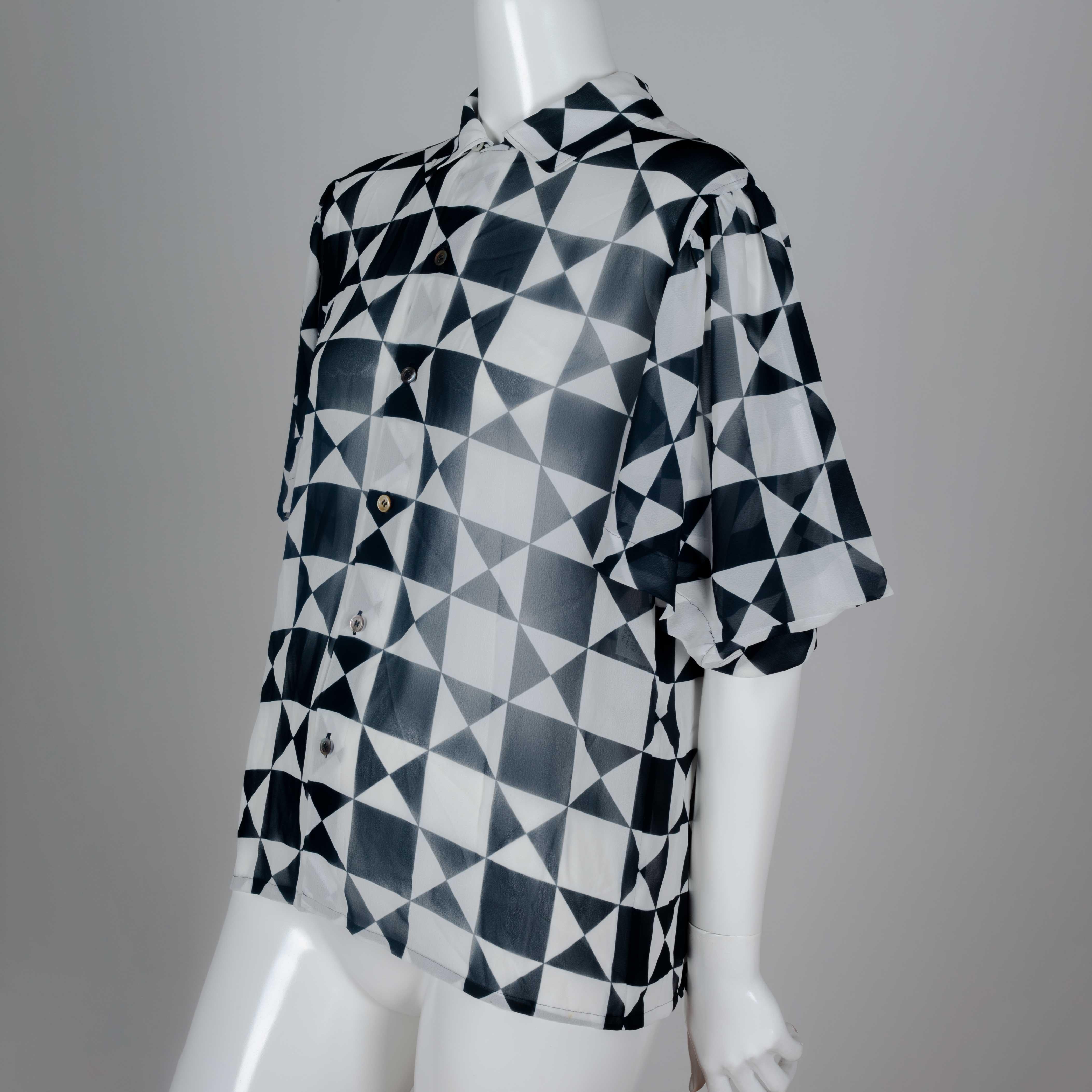 Comme des Garçons 1989 chiffon blouse from Japan with black and white geometric motif, short lantern sleeves and cut away collar. The boxy shape compliments the geometry of the print, and contrasts with the flowing material.    

YEAR: 1989
MARKED
