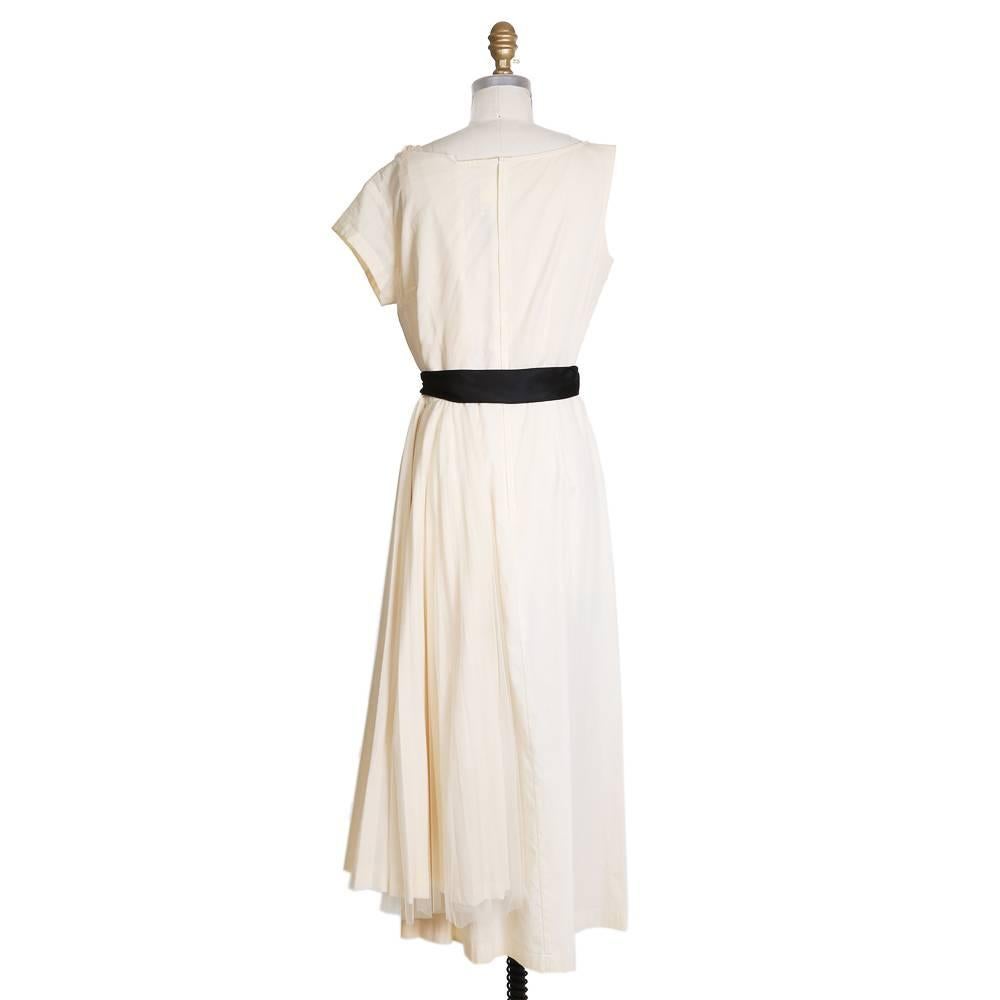 Product Details:
Dress by Comme Des Garcons from Spring Summer 2002
Cream colored cotton base
Pleated tulle skirt on one side
Black silk satin belt
Zipper closure in back
Condition: Excellent
Size/Measurements:
Size small
36