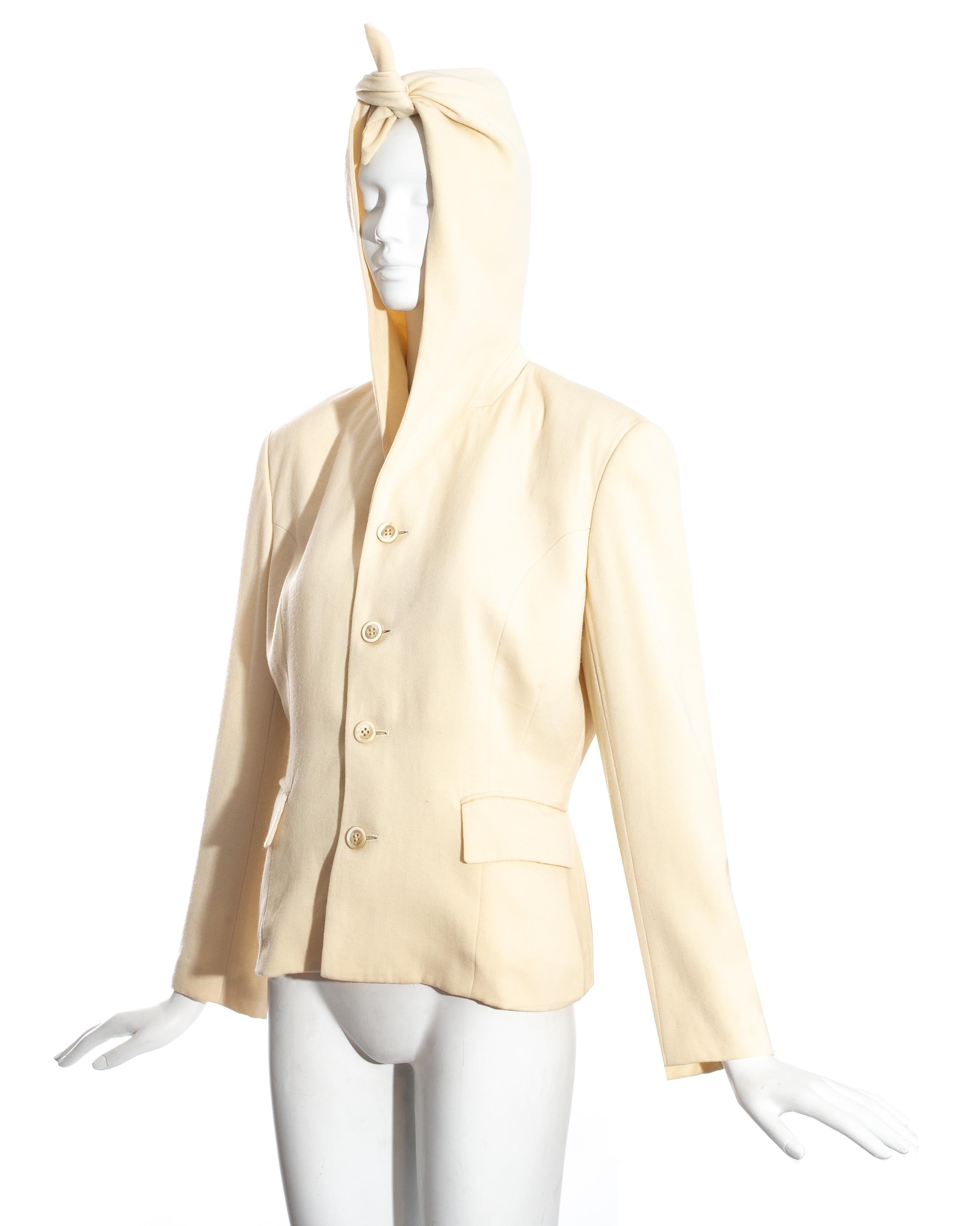 Comme des Garçons cream wool button up jacket with pointed hood which can be tied around the head or in a knot.

Fall-Winter 1988