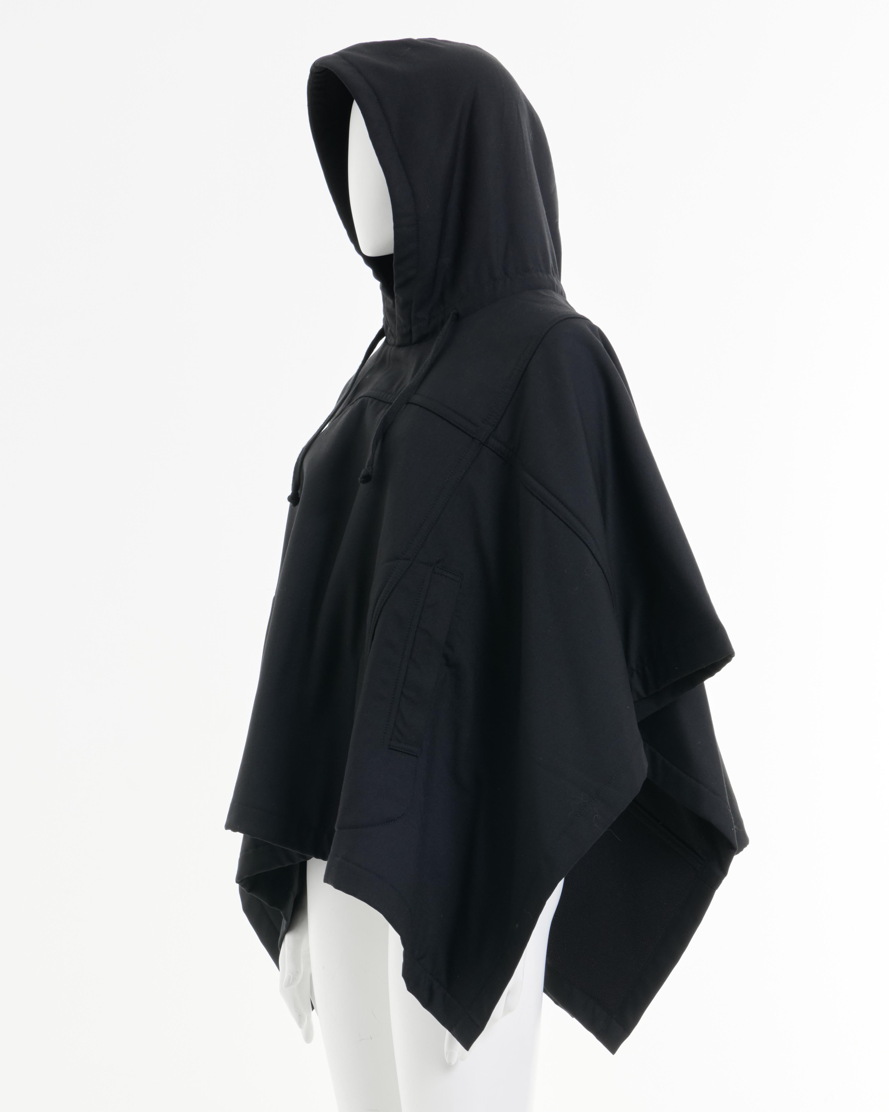 - Designed by Rei Kawakubo
- Sold by Skof.Archive
- Black hooded oversized cape
- Asymmetrical hemline
- Functional side pockets
- Relaxed fit
- Excellent Condition
- Made in China
- Materials: 55% Polyester, 45% Wool
- Size: FR 36 - EN 40 - UK 8 -