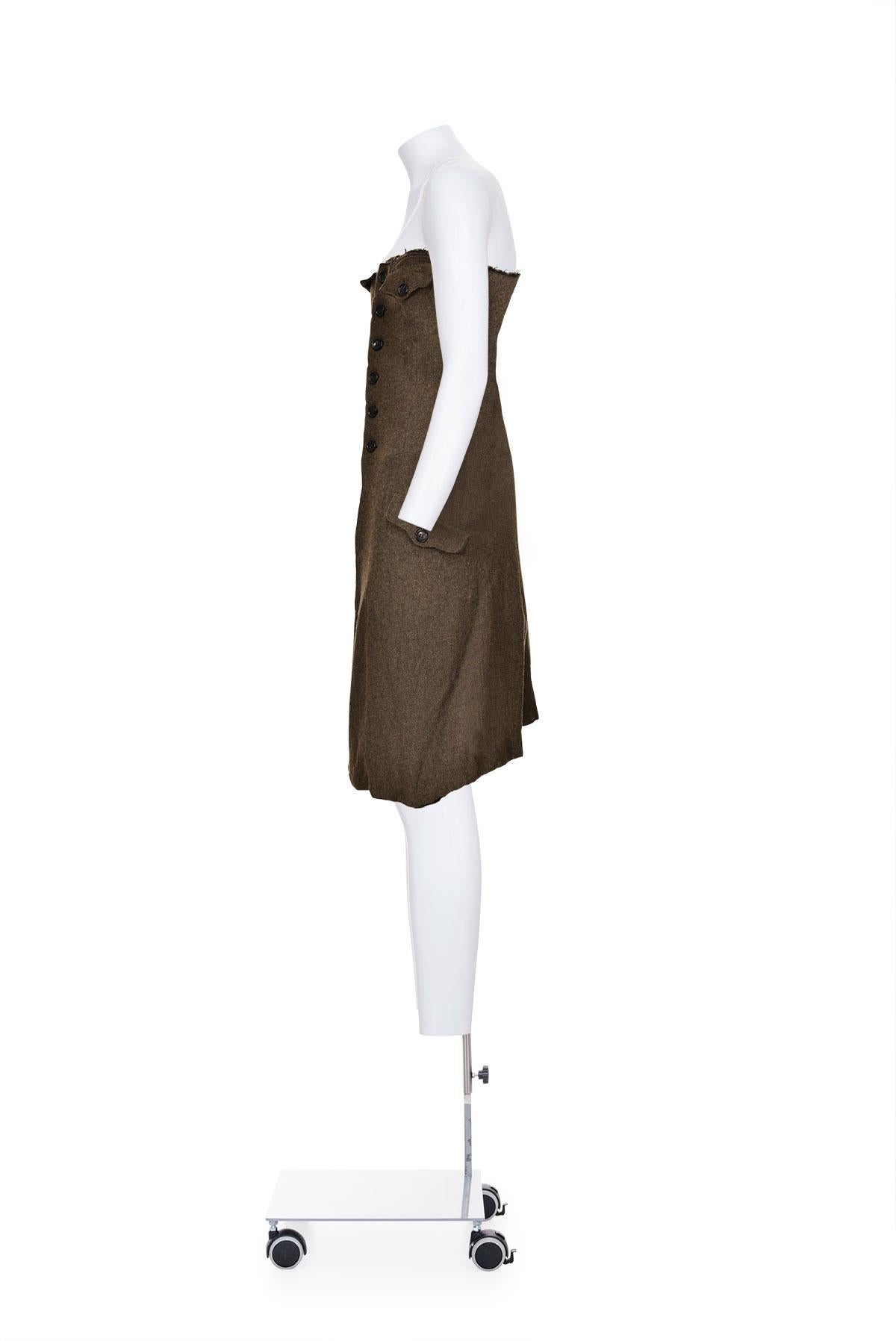 Fall Winter 1994 felted wool strapless military dress by Comme des Garçons. 
Buttons closure at the front. 
Pockets at chest and hips. 
Raw edges.
The composition is 90% wool and 10% nylon. 