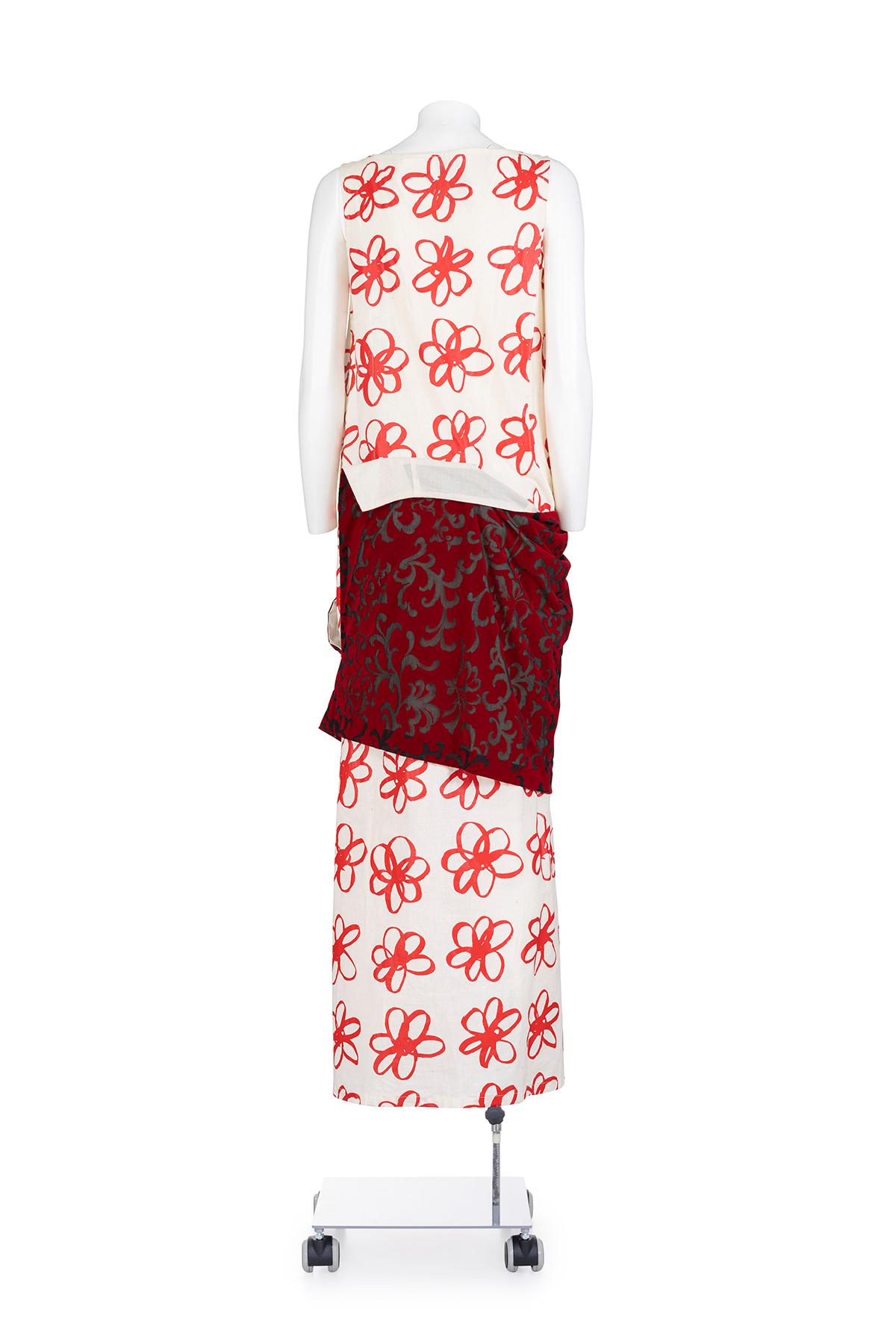 Herbst-Winter 1998 kultiges und seltenes langes Kleid mit Blumenmuster aus Gummi von Comme des Garçons.
V-Ausschnitt. 
Devorè Rock mit Samtapplikation.
Die Zusammensetzung ist 100% Polyester.