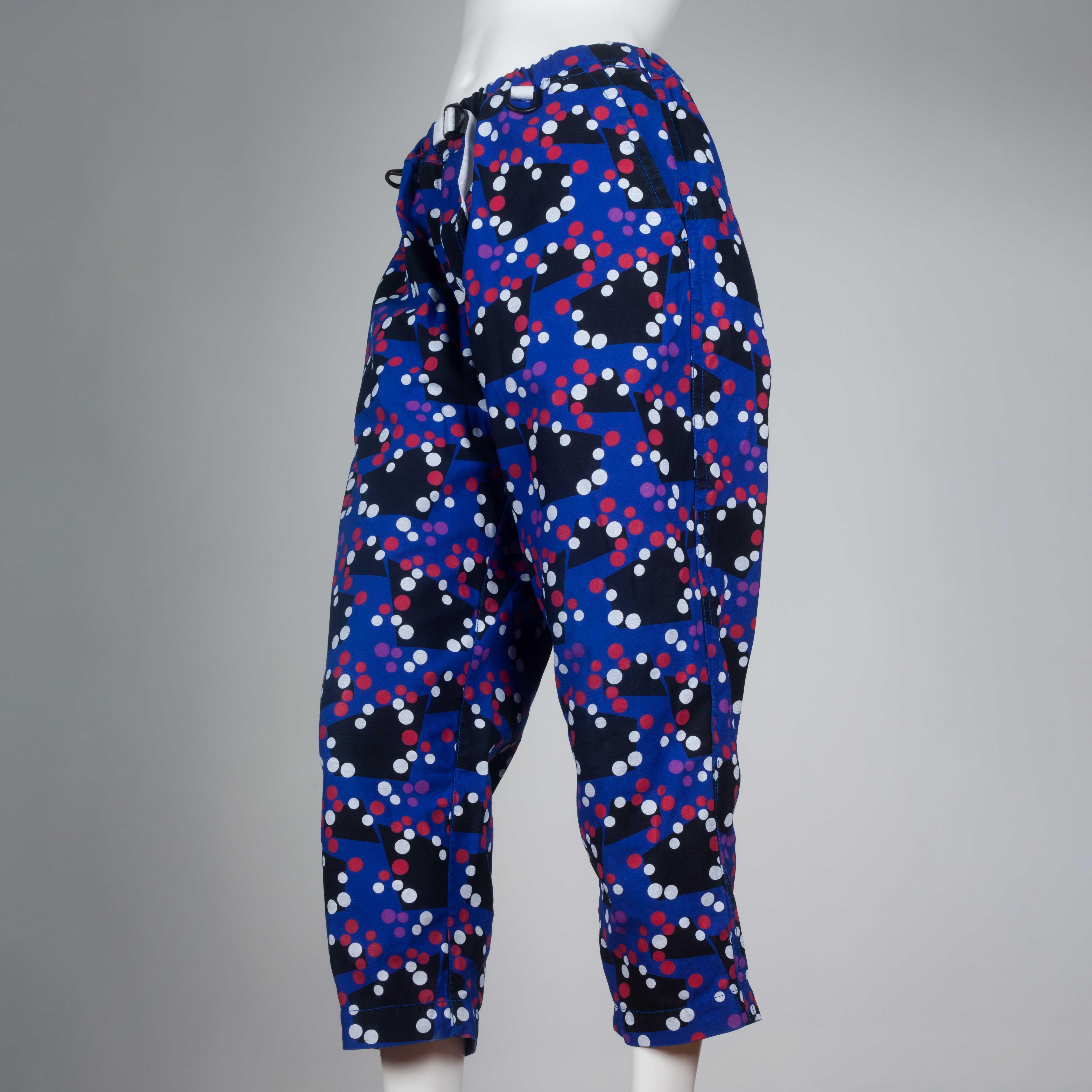 Comme des Garçons Ganryu 2012 trousers in blue with black geometric pattern, and covered in red and white dots. Elastic waist with a white adjustable integrated belt. Yayoi Kusama feels. 
 
YEAR: 2012
MARKED SIZE: M
US WOMEN'S: M
US MEN'S: S
FIT: