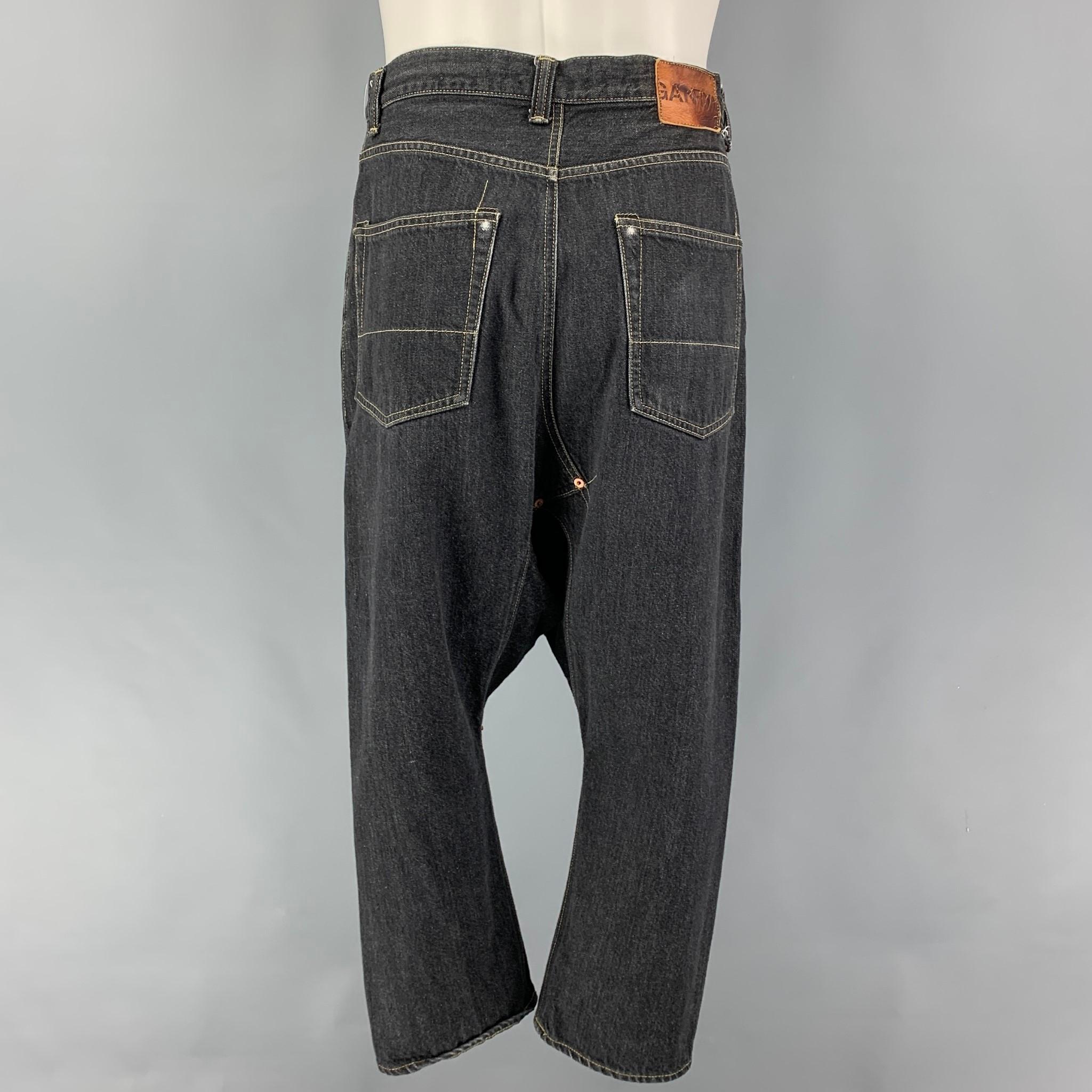 COMME des GARCONS GANRYU jeans comes in a charcoal selvedge denim featuring a drop-crotch style, contrast stitching, ad a zip fly closure. Made in Japan. 

Very Good Pre-Owned Condition.
Marked: S / AD2015

Measurements:

Waist: 32 in.
Rise: 12.5