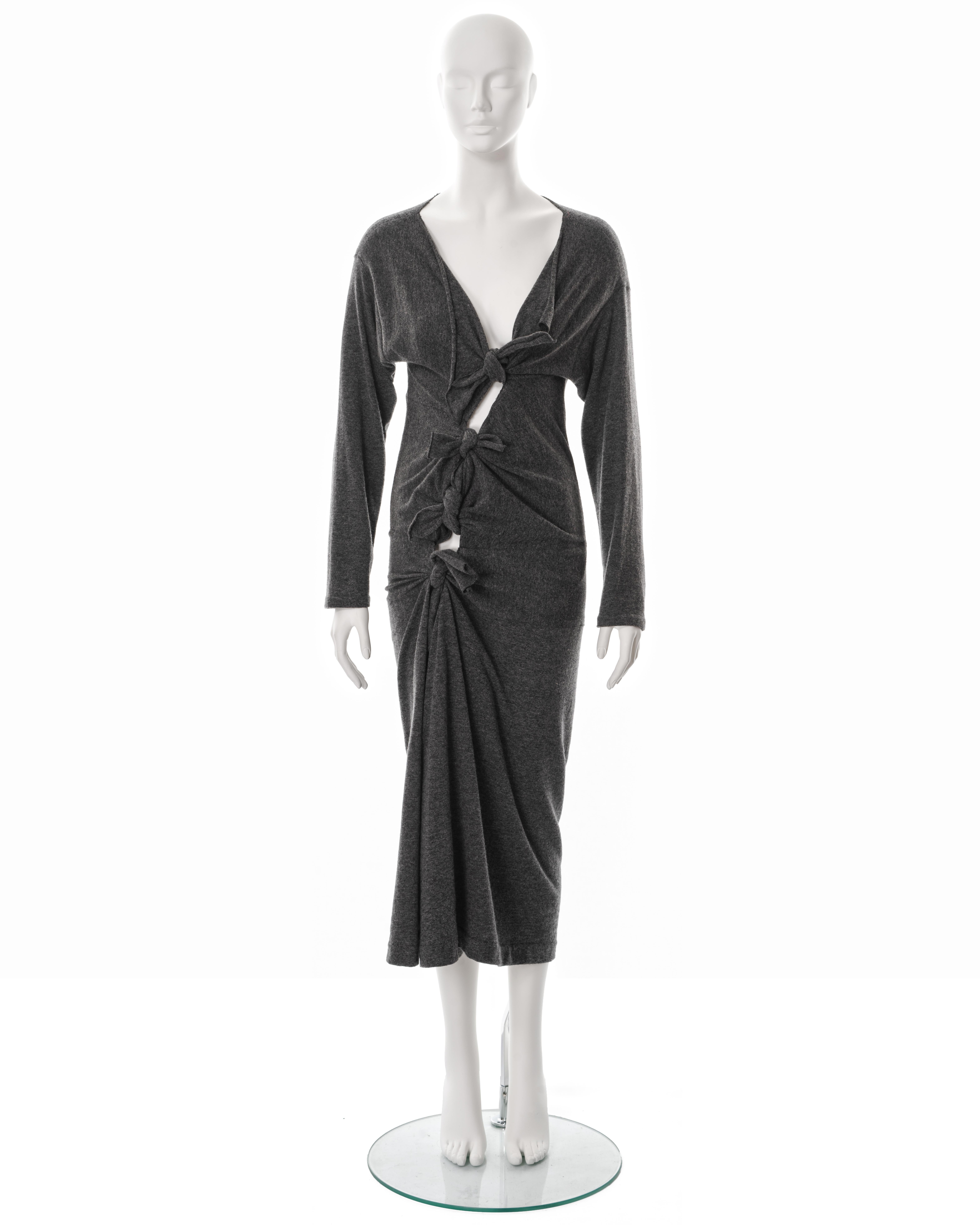 ▪ Comme des Garçons dress 
▪ Designed by Rei Kawakubo
▪ Fall-Winter 1983 
▪ Museum piece 
▪ Constructed from a grey 80% Wool - 20% Nylon jersey with a nubbled texture 
▪ Several front ties which can be knotted and styled in multiple ways 
▪